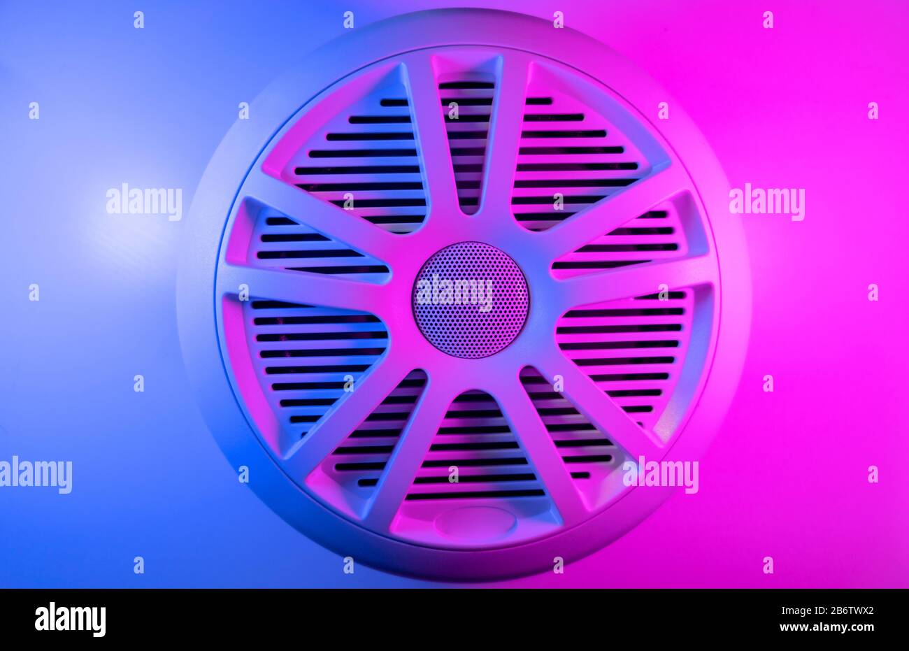 Luci colorate dello stereo dell'auto e dello sfondo degli altoparlanti dell'auto. Altoparlante audio per auto con toni blu e rosa. Primo piano del moderno impianto audio per auto Foto Stock