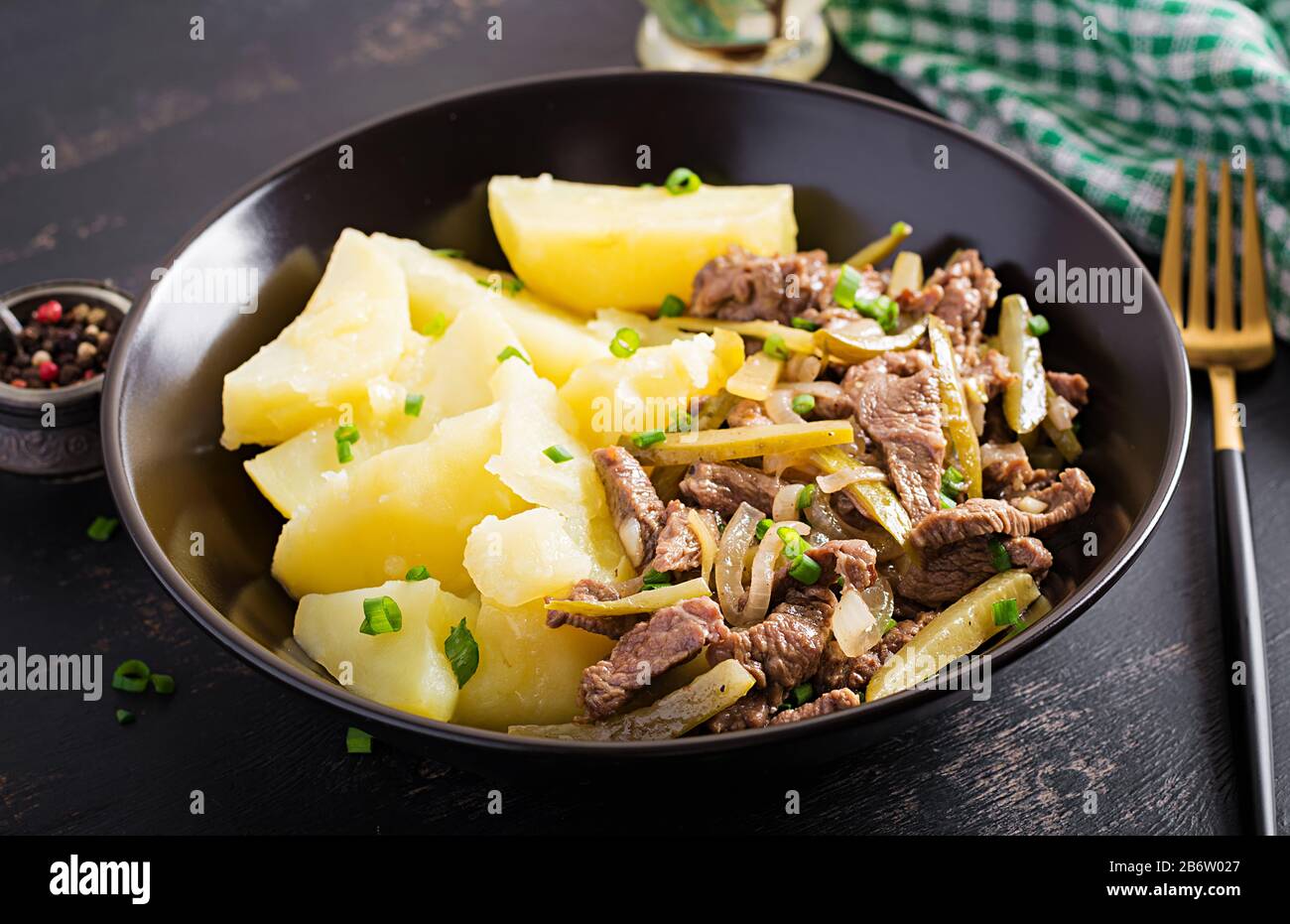 Stufato di manzo, pezzi di manzo stufati con cetriolo decapato in stile russo. Stroganoff di manzo e patate bollite. Foto Stock