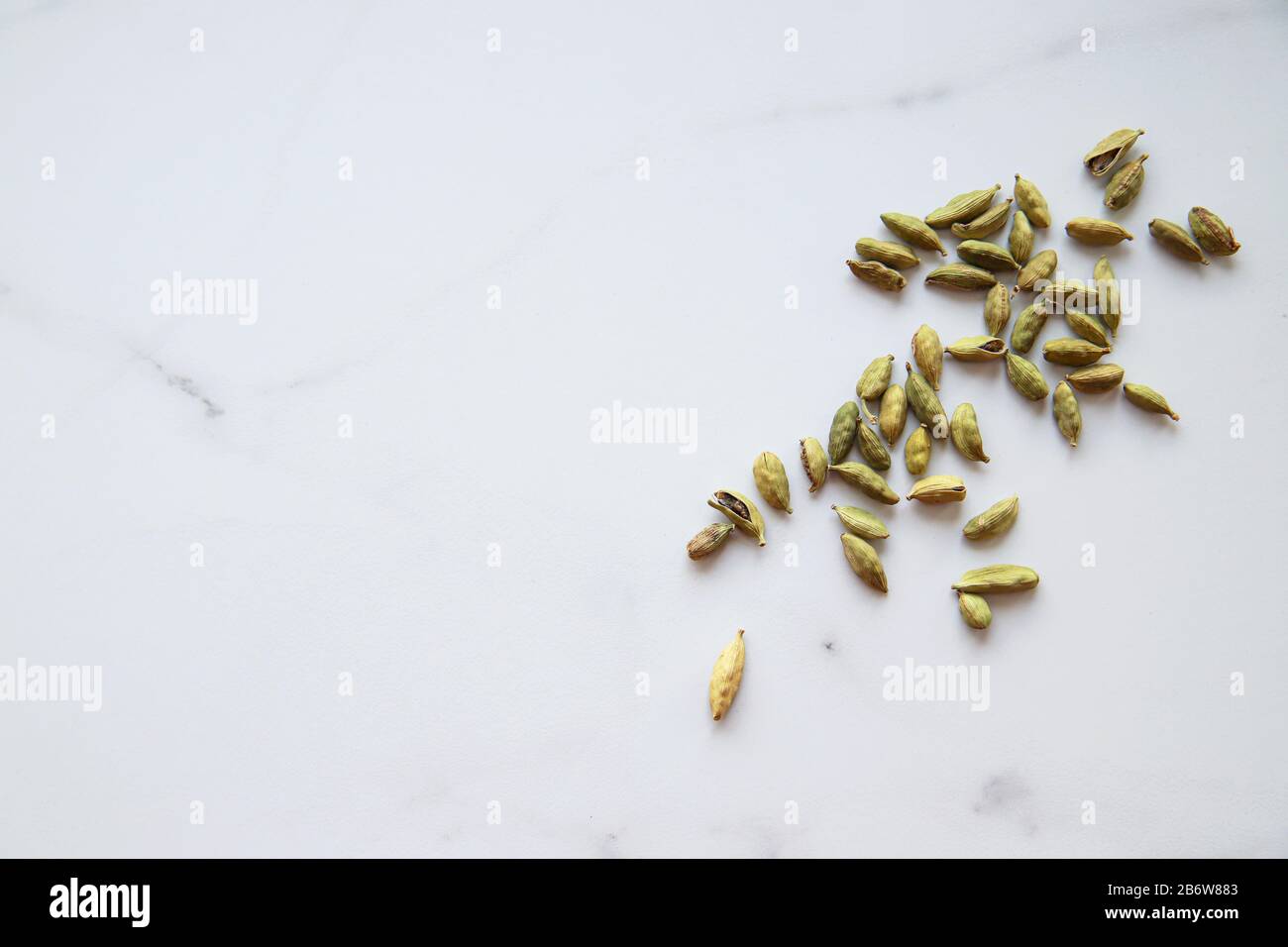 Semi di cardamomo con spazio copia. Concetto di spezie verdi e sane. Condimento per cibo e bevande. Vista dall'alto e disposizione piatta Foto Stock