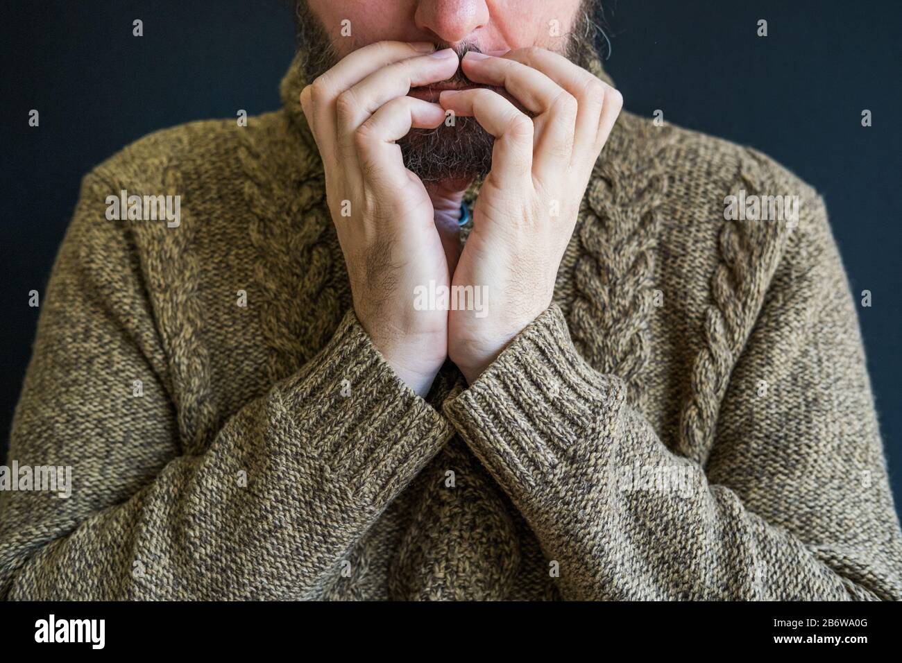 Infelice uomo in depressione, testa appoggiata su braccia incrociate Foto Stock