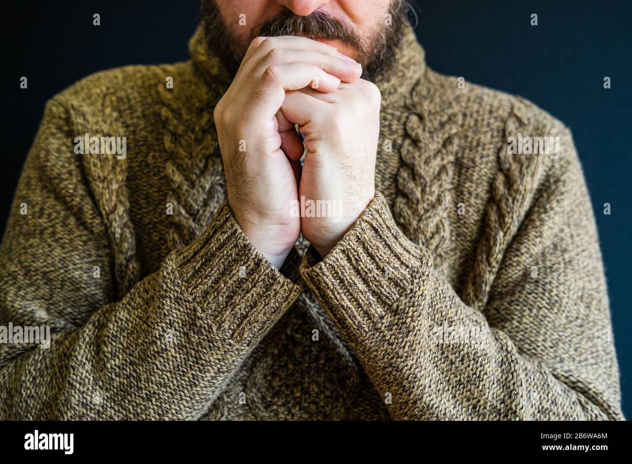 Infelice uomo in depressione, testa appoggiata su braccia incrociate Foto Stock