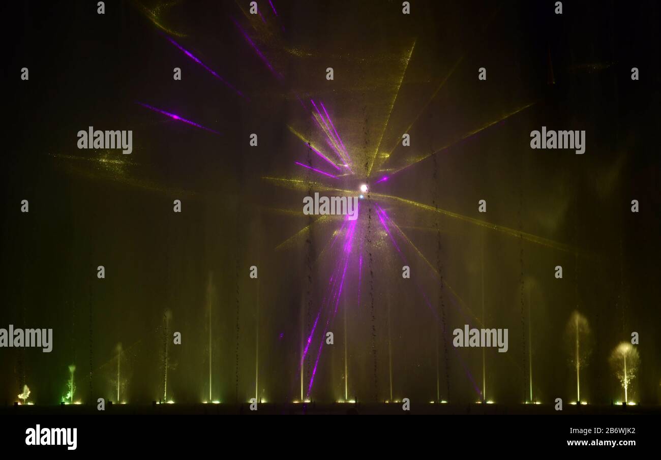 Fontane colorate. Bella laser e fontane spettacolo. Grande spettacolo di fontana luminosa a getto d'acqua con danza decorativa multicolore di notte. Scuro Foto Stock