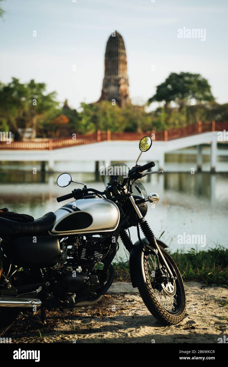 Moto di fronte al lago con antiche rovine civilistiche sullo sfondo Foto Stock