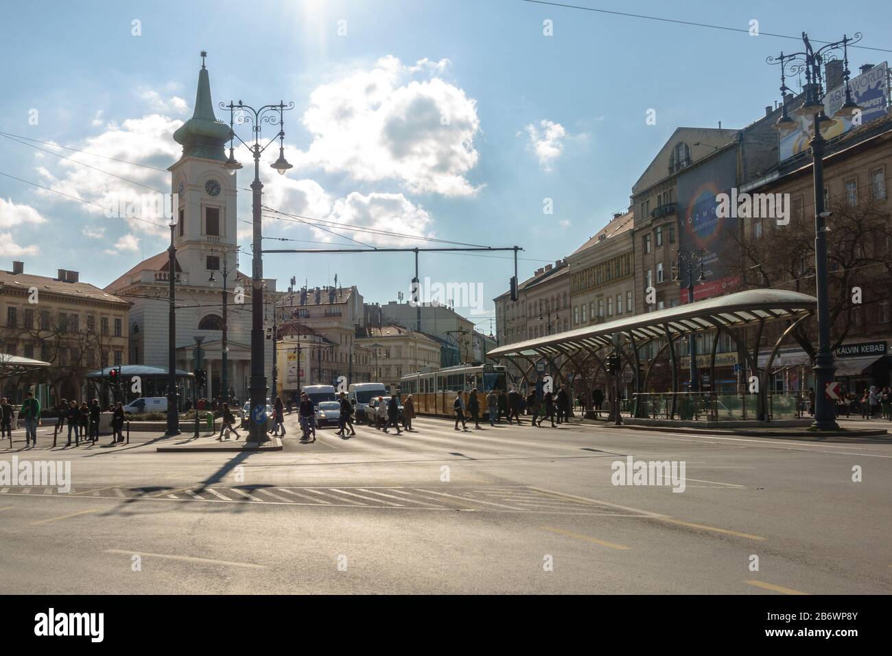 Persone che attraversano la strada per la fermata del tram Kalvin ter a Budapest, Ungheria Foto Stock