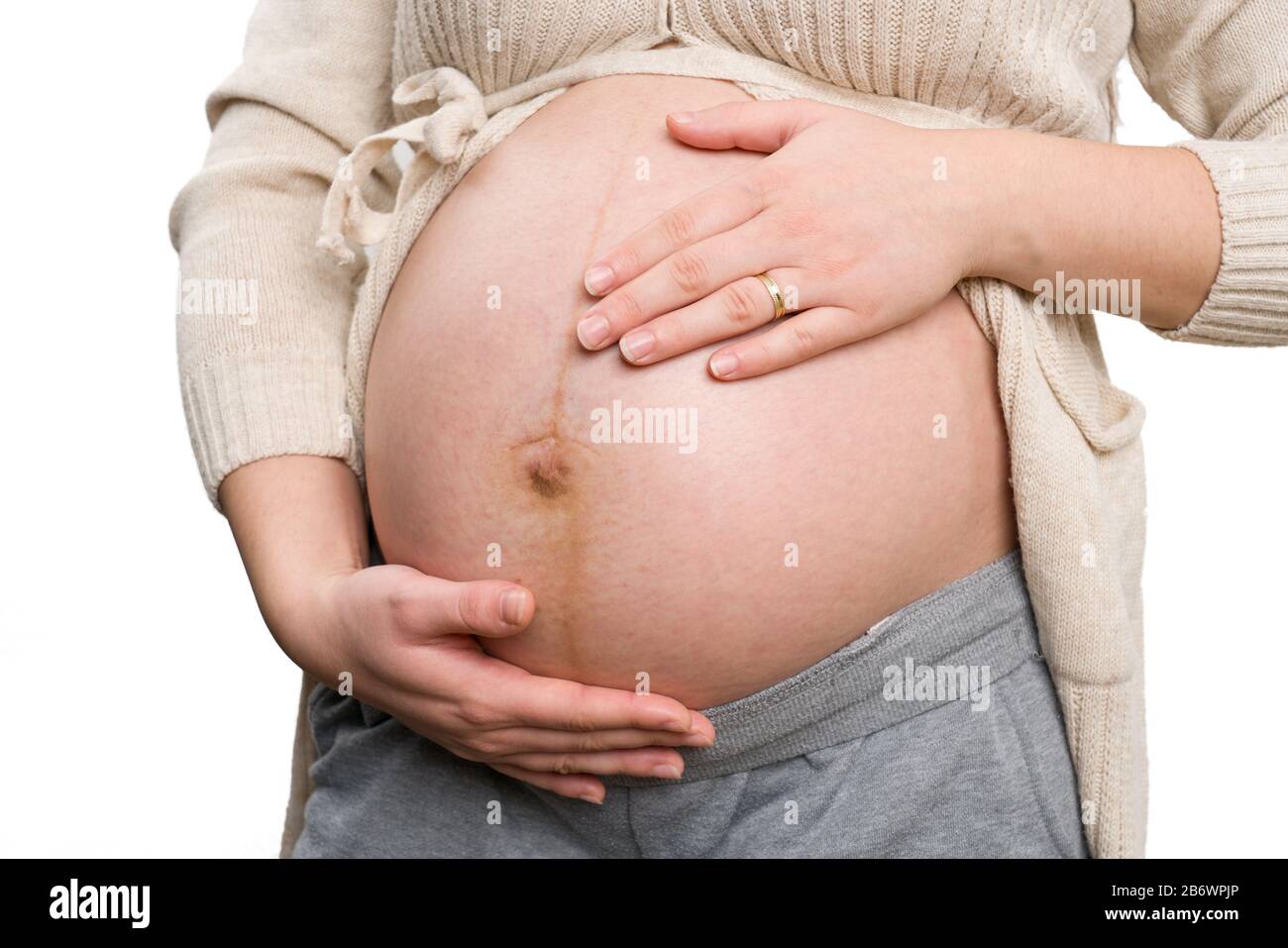 Primo piano della donna incinta che tiene la pancia isolata su sfondo  bianco come nove mesi di gravidanza concetto Foto stock - Alamy