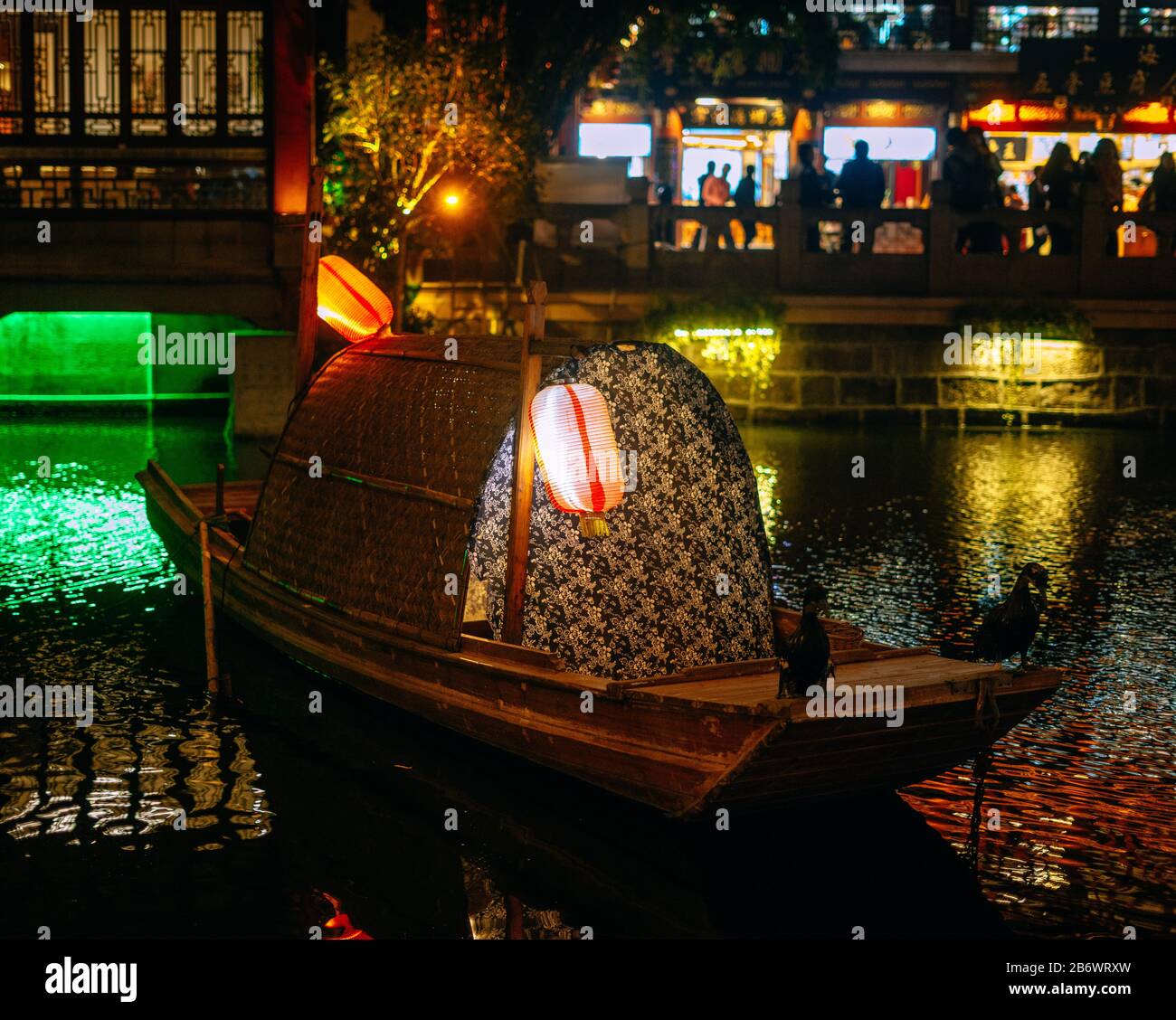 Tradizionale barca cinese con lanterne di carta e luci in un lago di notte Foto Stock
