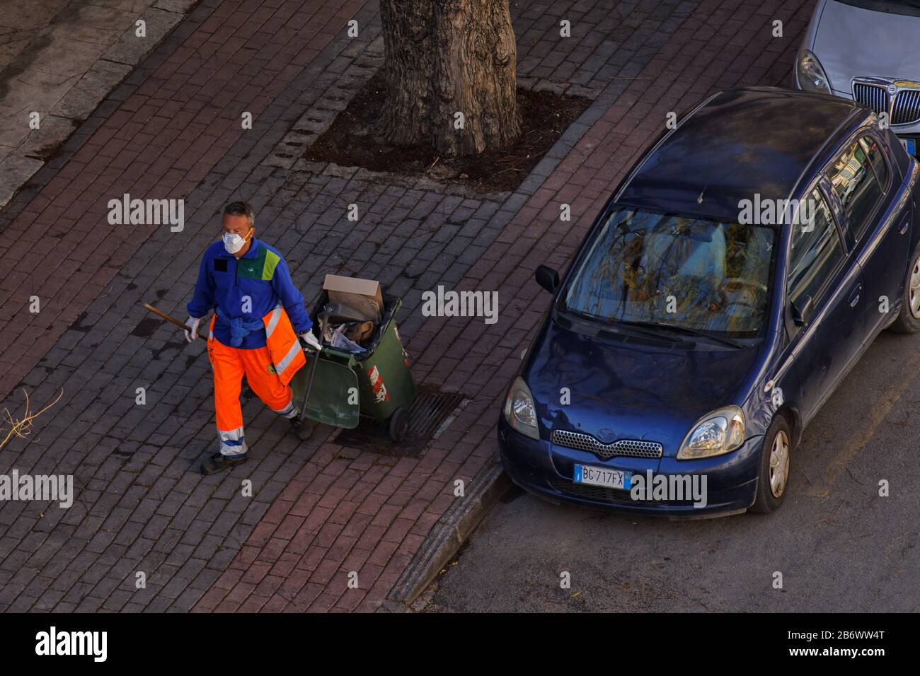 Raccolta di rifiuti mascherati su Lincoln Street che prende i rifiuti durante la pandemia del virus della corona COVID-19 a Palermo, Sicilia 2020 Foto Stock