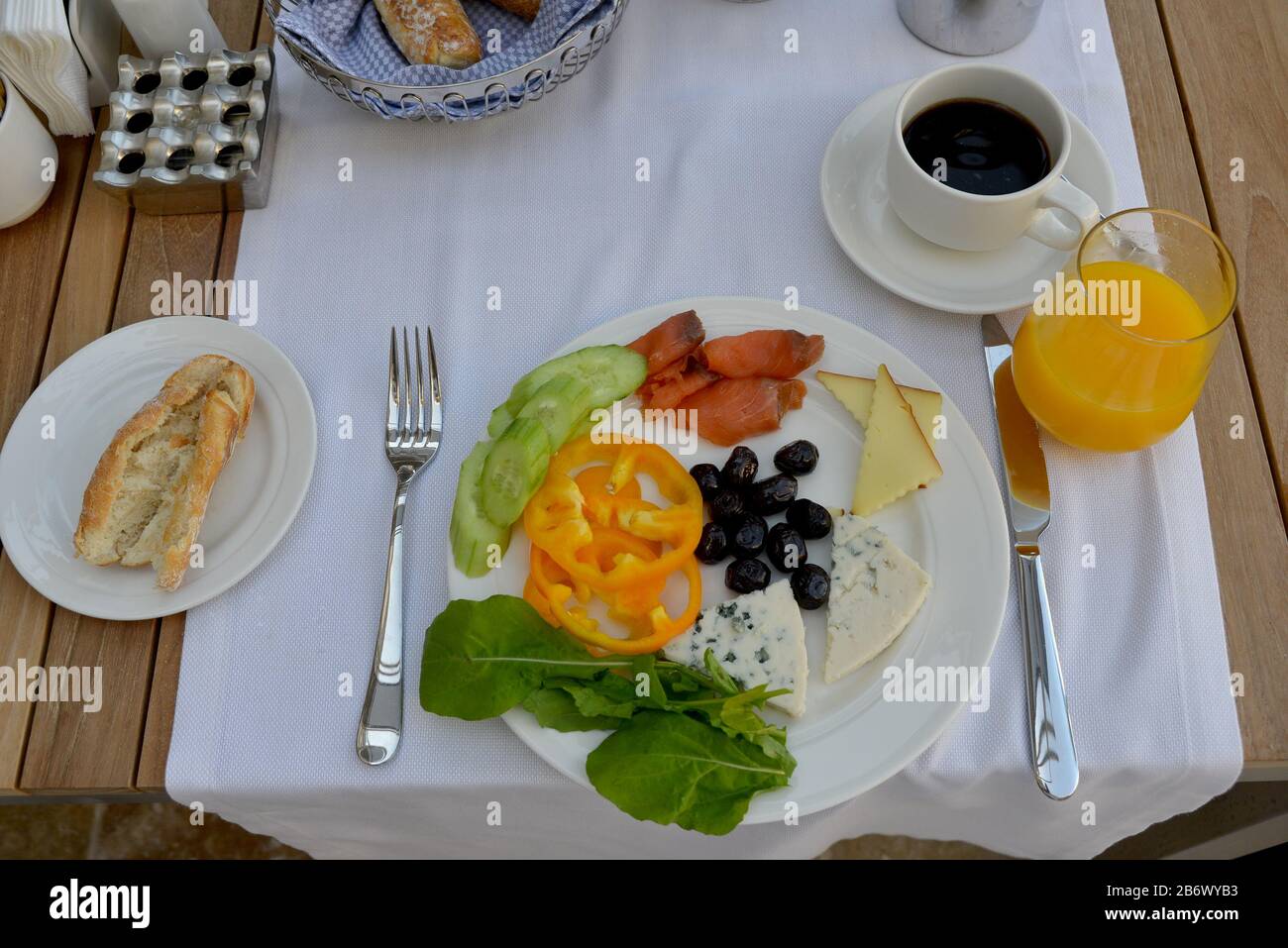 La colazione si conclude: Olive, pepe dolce, formaggio, roquefort, cetrioli, insalata, pesce rosso (salmone) + succo d'arancia e caffè nero. Il cibo è situato Foto Stock