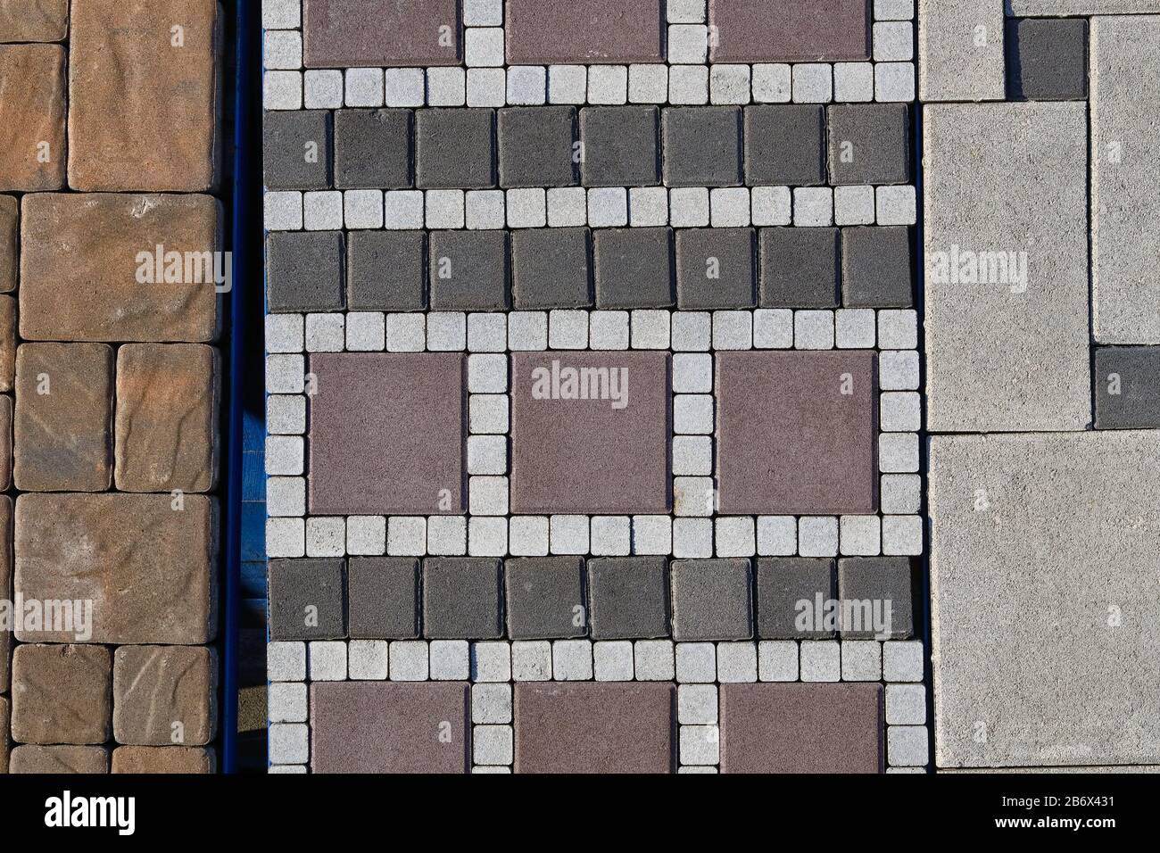 Pietra grigia di pavimentazione in cantiere. Pavimentazione di lastre per la posa di strade in magazzino. Costruzione di marciapiedi. Foto Stock