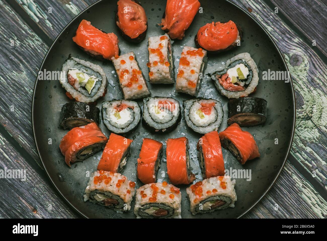 Rotolo assortito e sushi su un bel piatto rotondo o vassoio su un tavolo di  legno in un macro shot ristorante Foto stock - Alamy