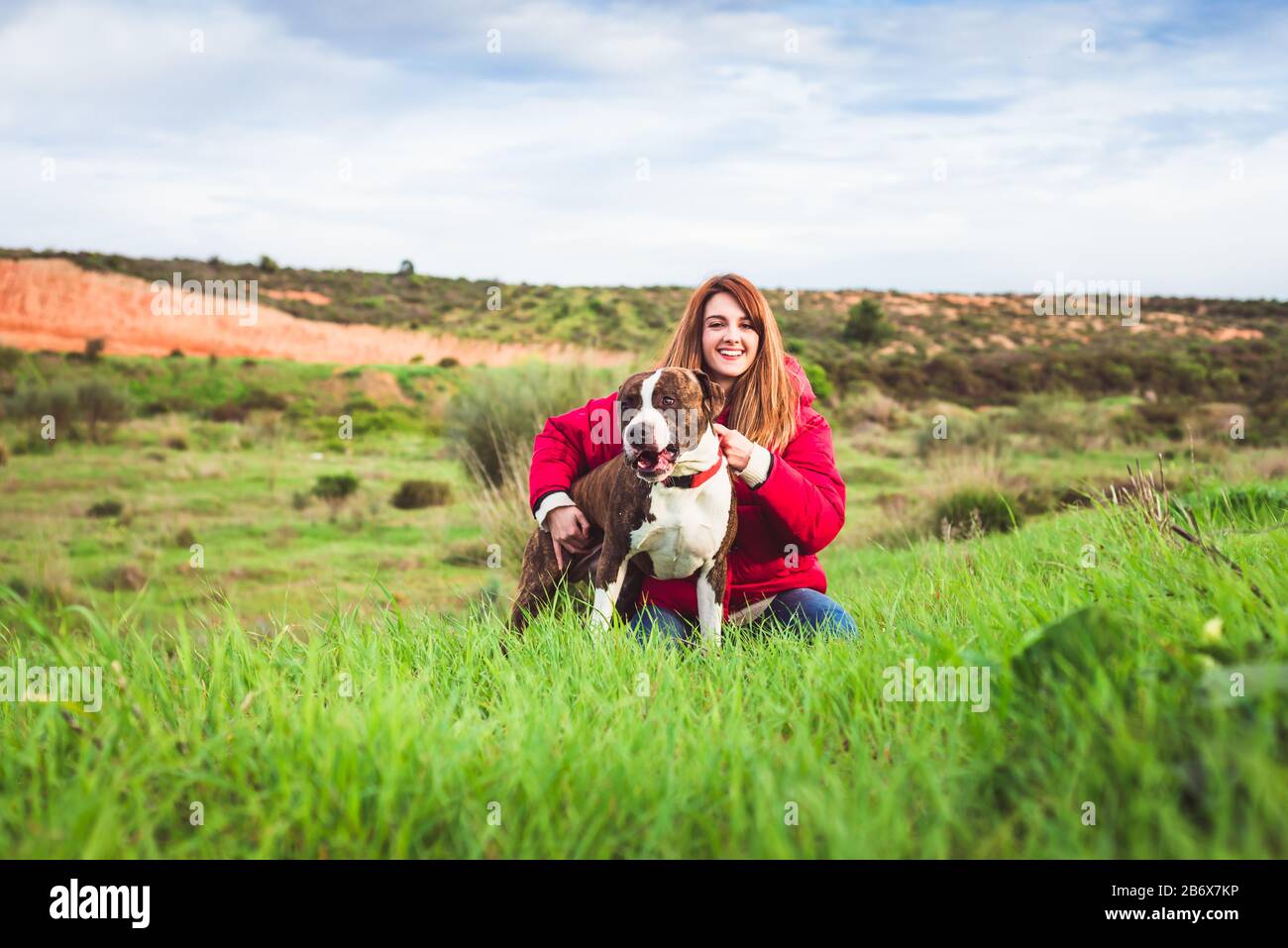 Giovane donna seduta con il terrier americano di Staffordshire Foto Stock