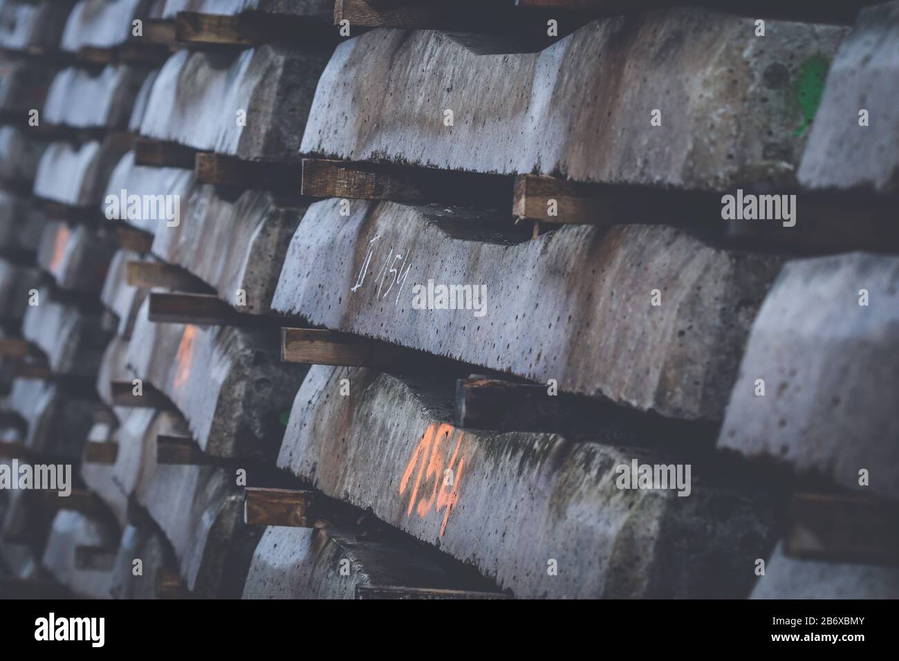 Nuove traversine ferroviarie in calcestruzzo impilate su file pronte per giacere sotto il binario ferroviario Foto Stock