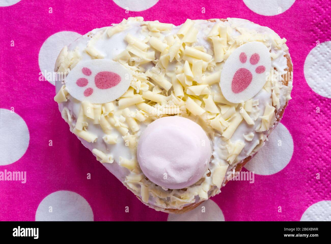 Bunny Bum Donut fresco dalla panetteria a Marks & Spencer su tovagliolo di serviette rosa e bianco Foto Stock