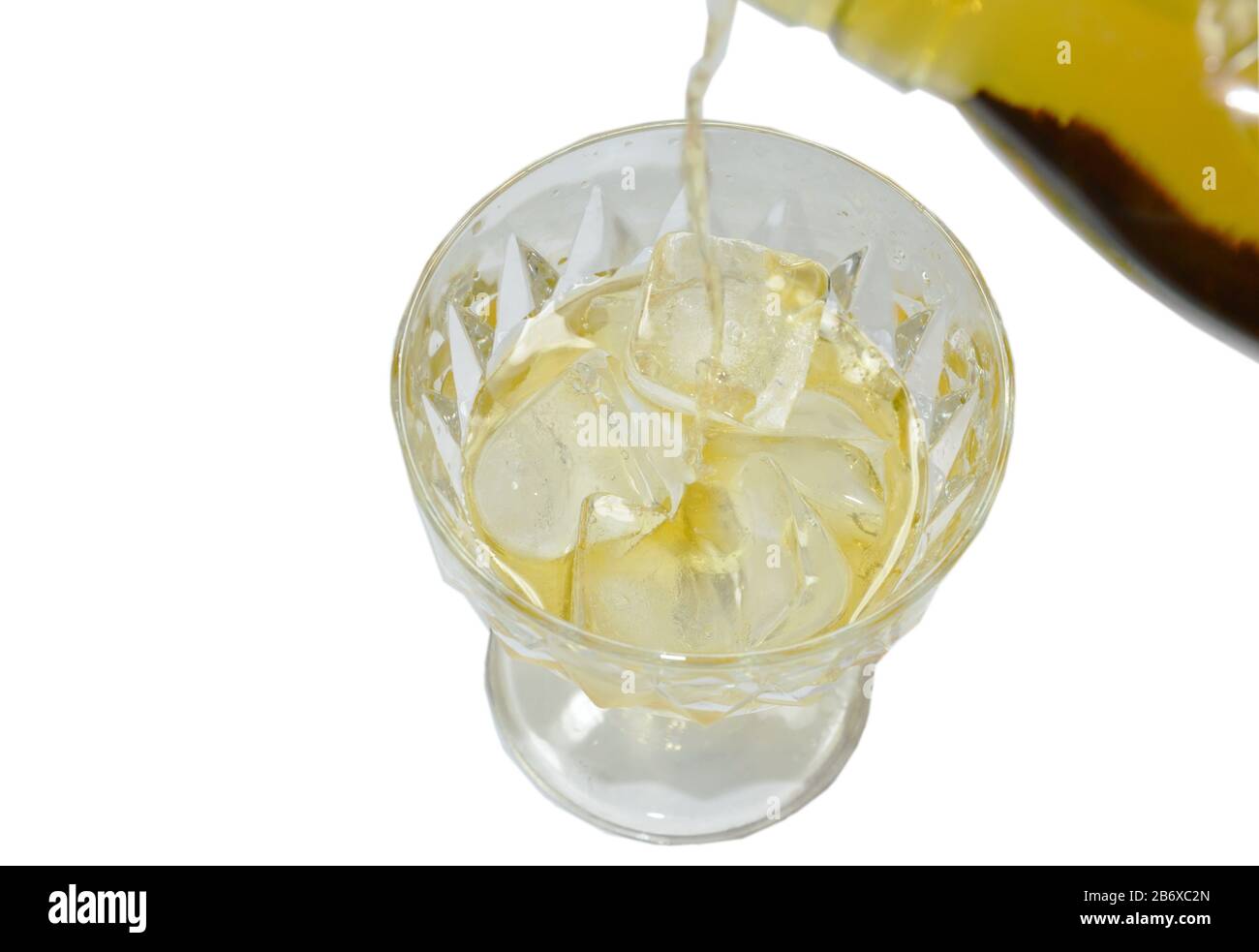 versare il whiskey dalla bottiglia su ghiaccio su fondo bianco Foto Stock