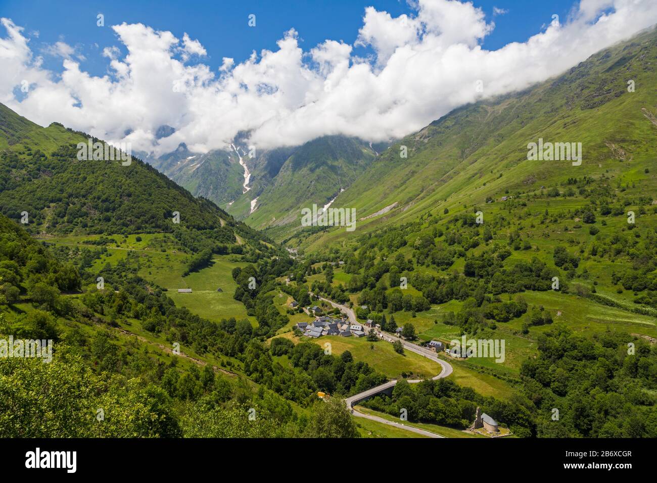 Villaggio Di Le Plan, Alta Garonna, Occitanie, Francia. La D118 conduce attraverso il villaggio e al Parco Nazionale dei Pirenei montagnosi oltre. Foto Stock