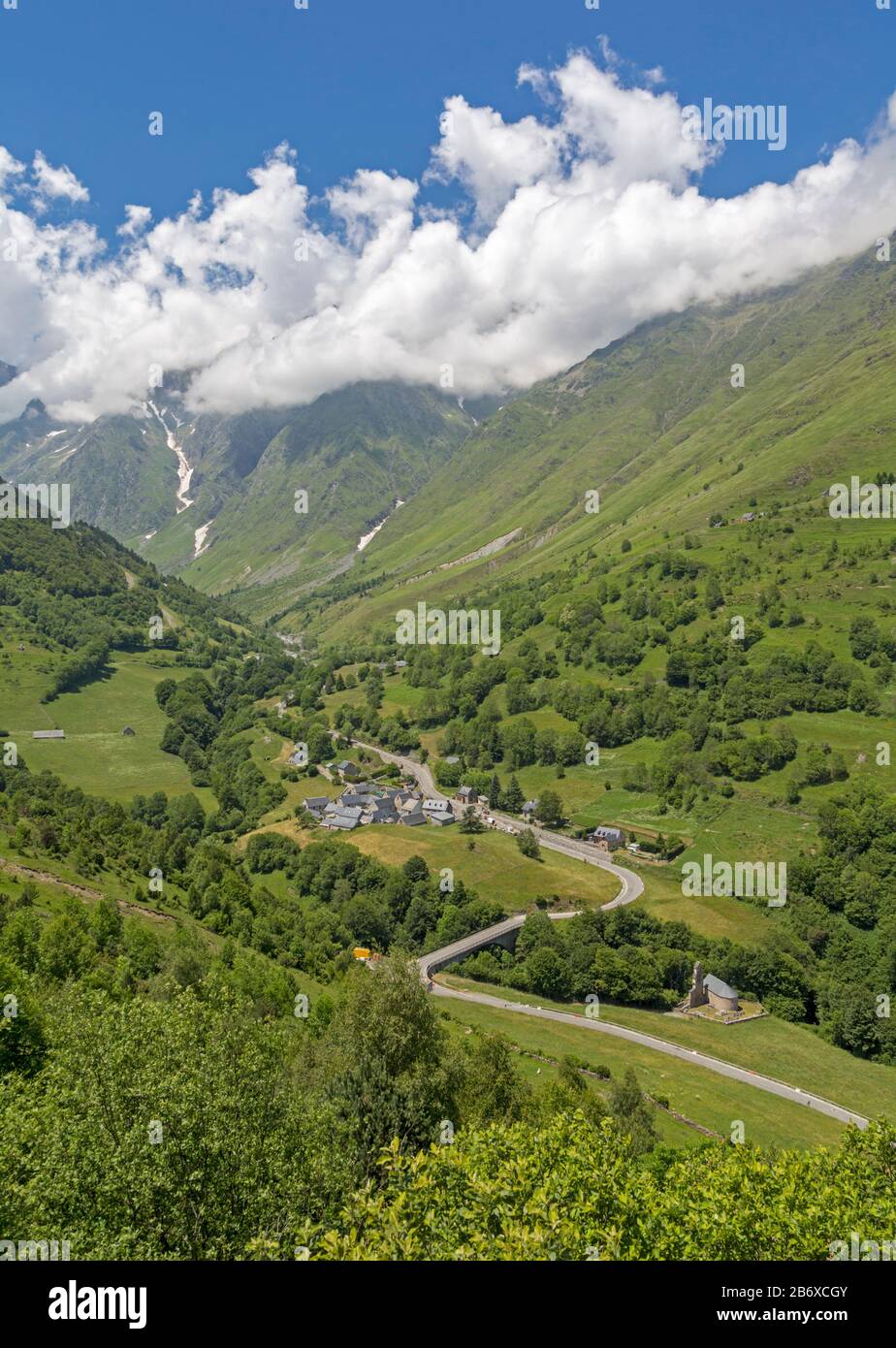 Villaggio Di Le Plan, Alta Garonna, Occitanie, Francia. La D118 conduce attraverso il villaggio e al Parco Nazionale dei Pirenei montagnosi oltre. Foto Stock