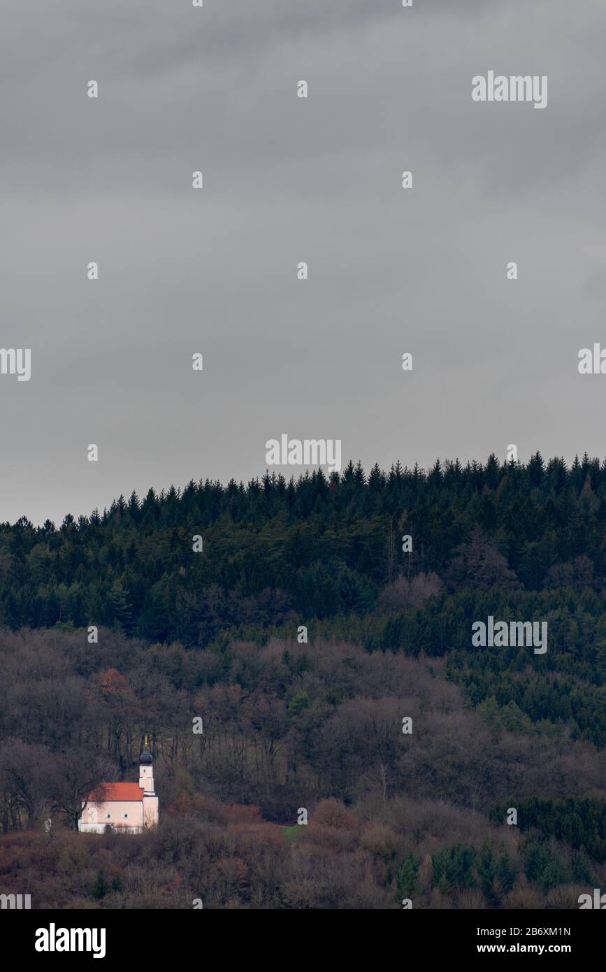 Piccola chiesa nel mezzo della foresta bavarese circondata da alberi in un giorno coperto Foto Stock