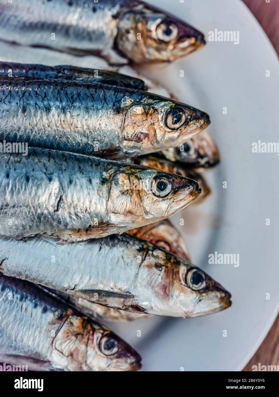 Un piatto di aringhe e sardine pronto su un tavolo Woden pronto per la cottura. Foto Stock