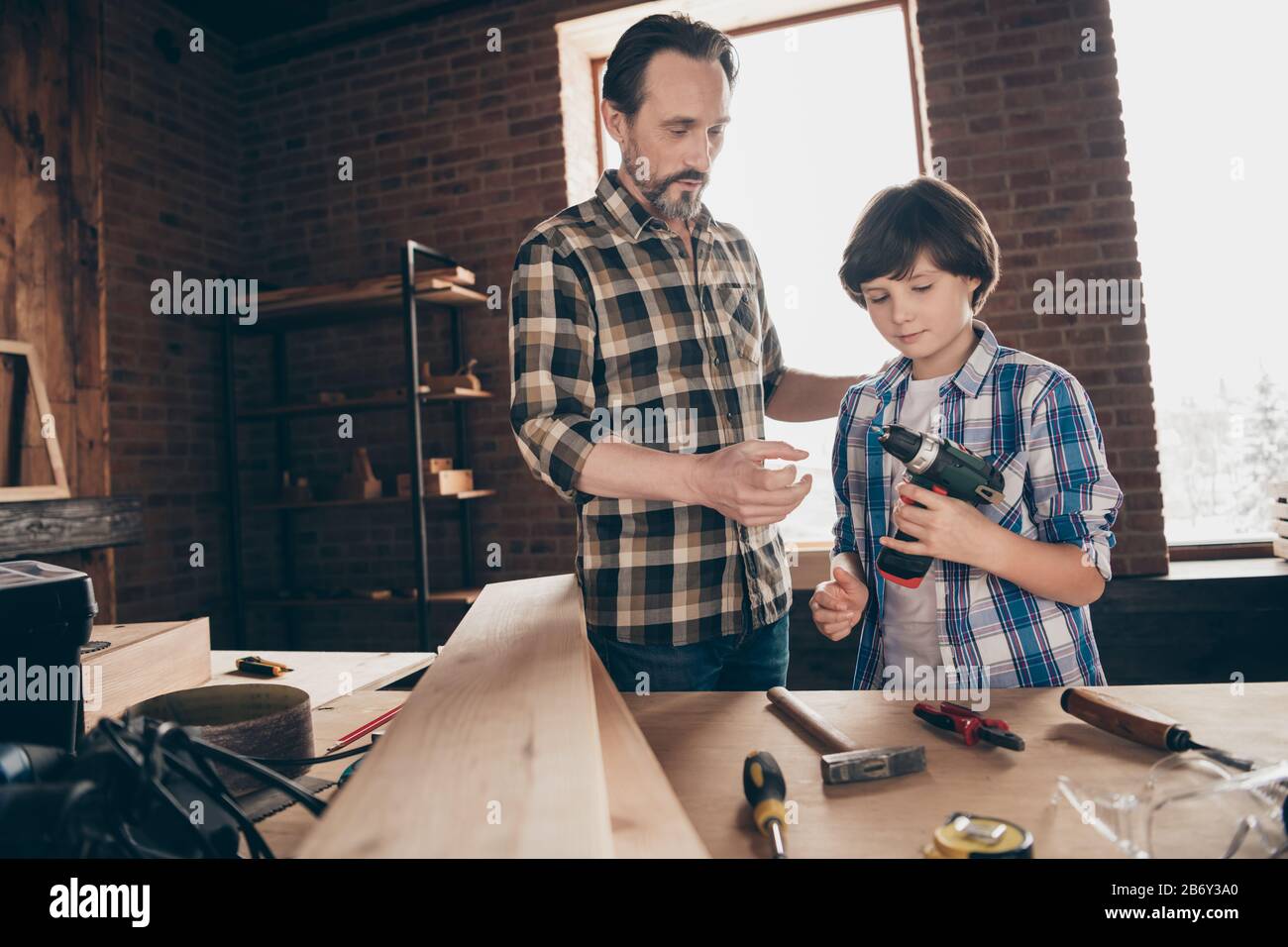 Ritratto di due bella persona messo a fuoco lavoratori del legno maestro handyman condividere esperienza competenze come utilizzare l'utensile elettrico professionale al loft moderno Foto Stock