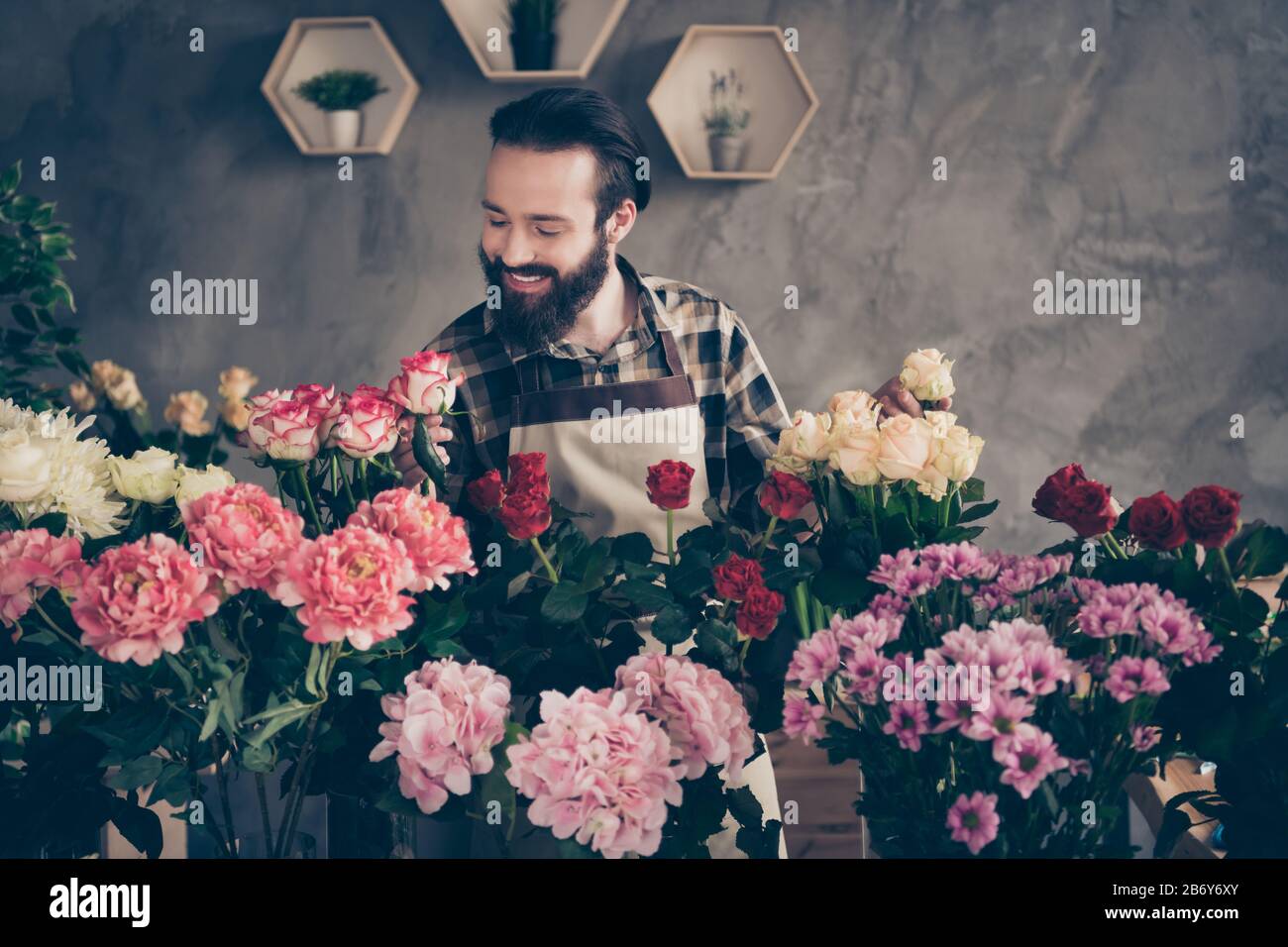 Ritratto di carino attraente maschio persona gioventù millennial tenere mano ambiente natura controllo qualità assaggiatori peony molte flora indossare abiti a plaid camicia Foto Stock