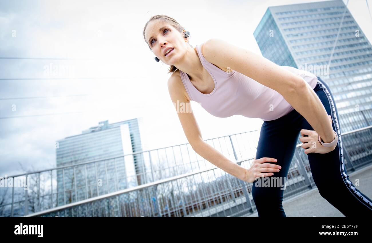 Sportliche Frau fängt ihren Atem nach dem Training. Femmina Runner che prende una pausa durante il suo jogging. Atleta donna rilassante dopo l'allenamento Foto Stock