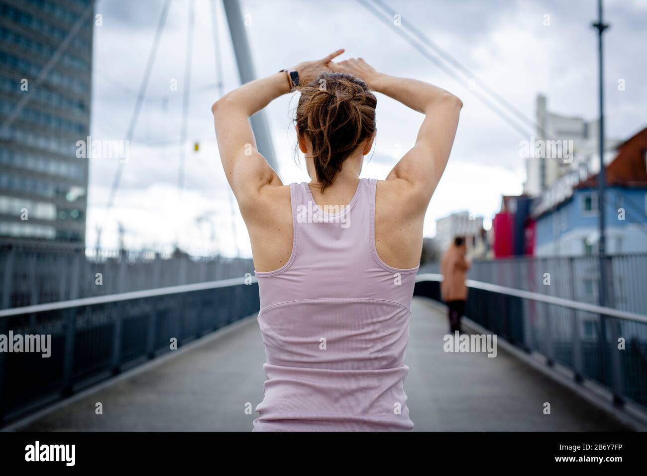 Aufnahme einer Sportlerin, die sich bereit macht für ein workout in der Stadt. Scatto di un atleta che si prepara per un allenamento in città. Foto Stock