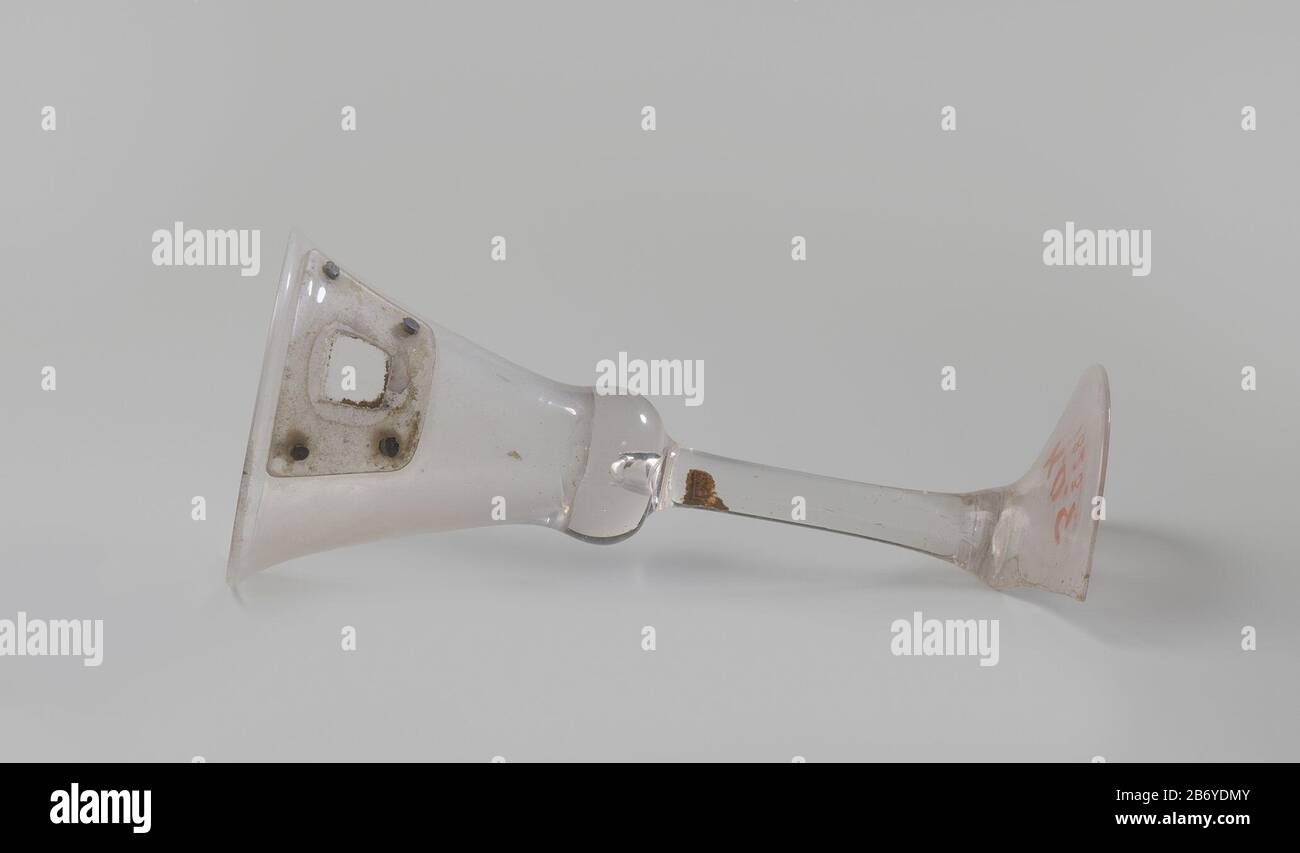 Kelkglas ha incontrato een gedichtte apertura onder de rand Kelkglas van helder, kleurloos glas. In de kelk, net onder de rand, bevindt zich een Opening die met een geklonken stuk glas gedicht is. De helft van de voet ontbreekt. Produttore : glasblazer: Anoniem Dating: CA. 1400 - ca. 1950 Materiale: Glas dimensioni: H 16,5 cm. × d 7,3 cm. Foto Stock