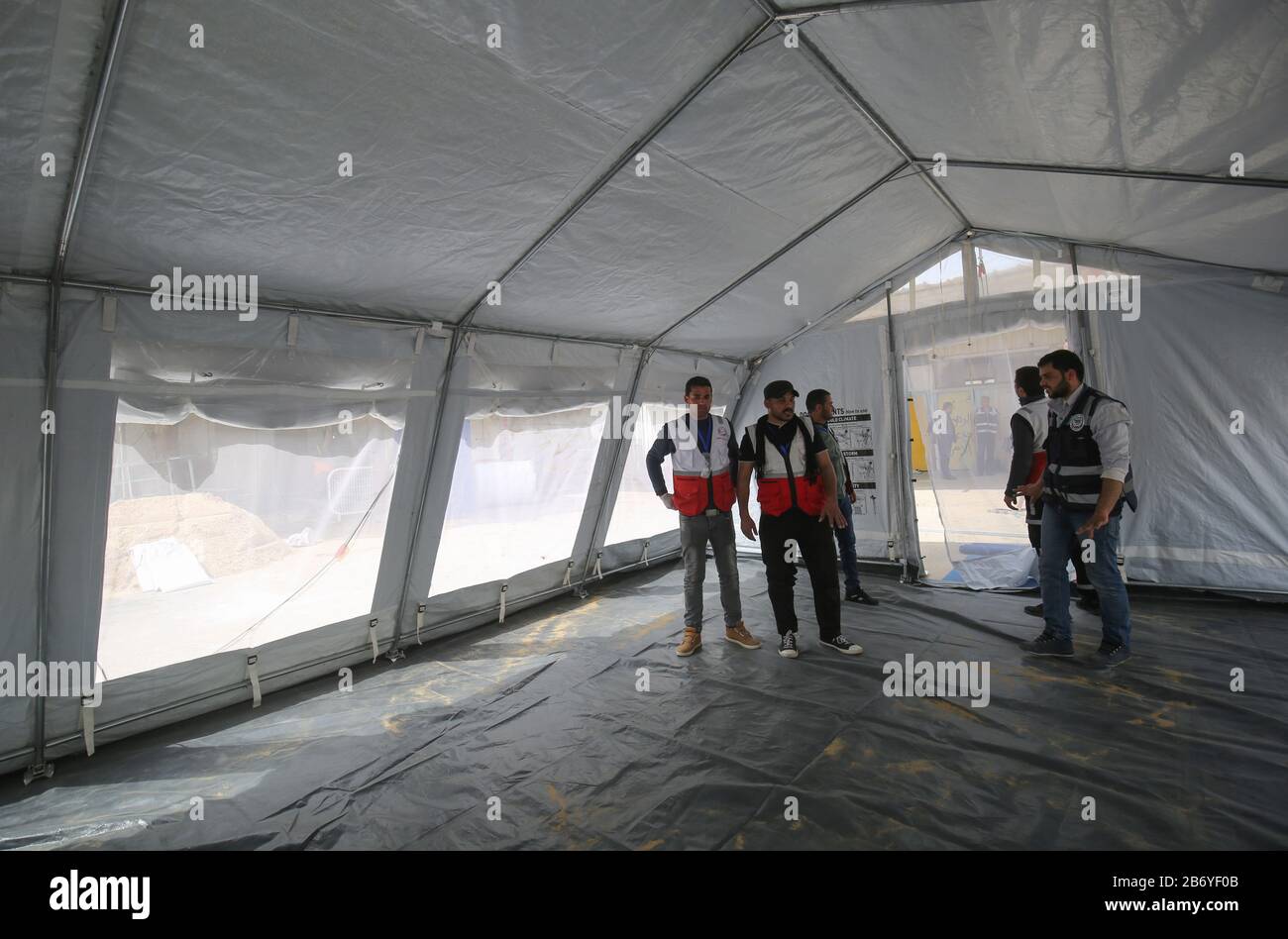 I lavoratori palestinesi hanno istituito tende per l'esame medico del virus Corona all'incrocio di Rafah con l'Egitto, nella striscia di Gaza, il 12 marzo 2020. Foto Stock