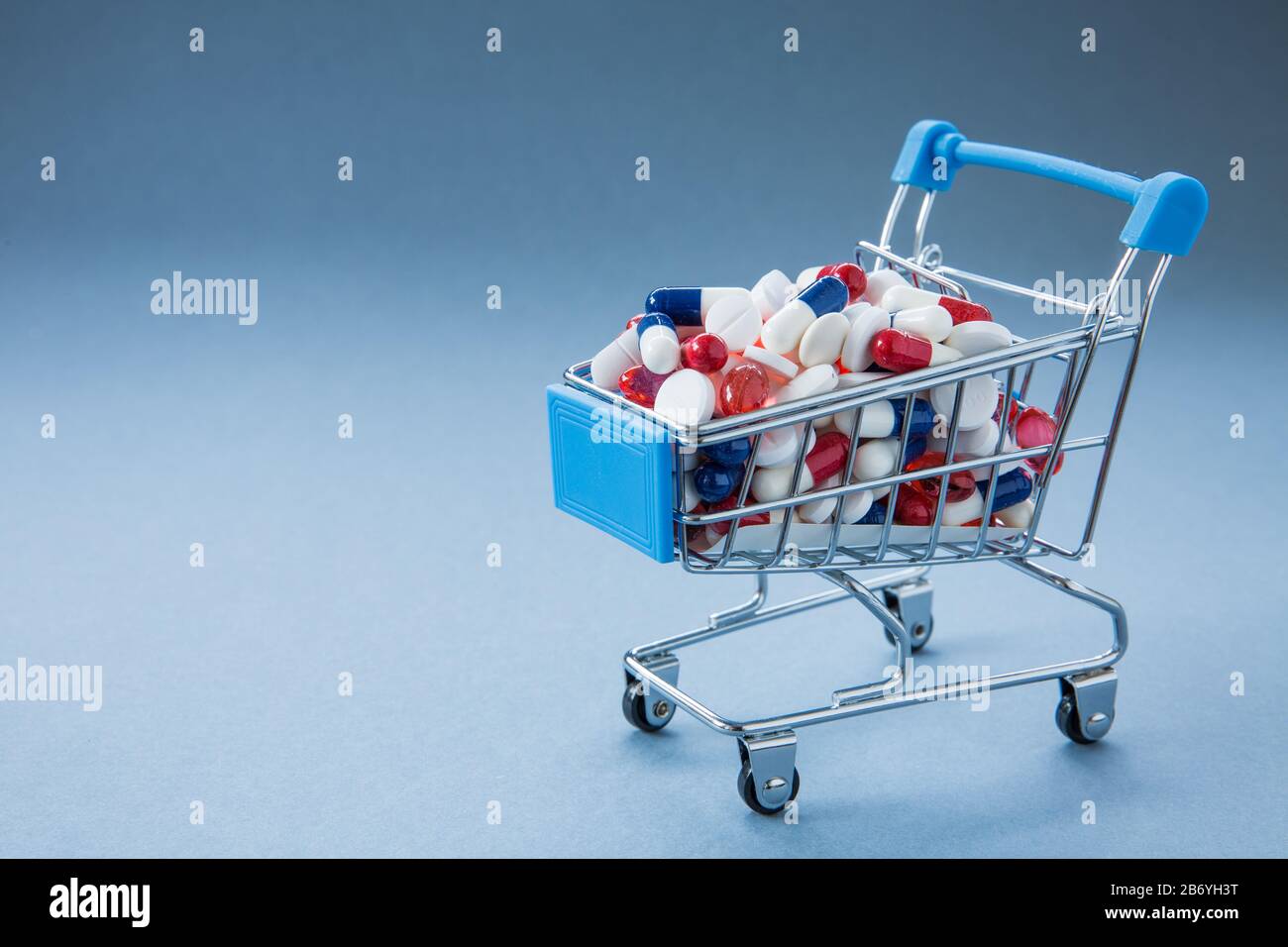 Un'immagine concettuale di una vendita al dettaglio, carrello o carrello pieno di pillole, tablet, antibiotici, antidolorifici che creano resistenza a virus e batteri Foto Stock