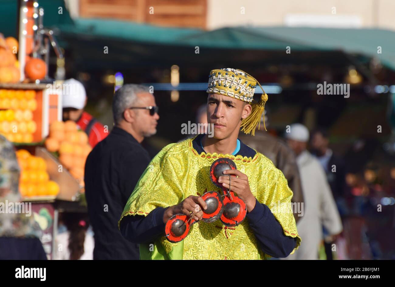 Un musicista Gnaoua/Gnawa che suona Krakebs/Qarkabebs, Castinetti marocchini, mentre intrattiene i turisti a Jemaa el-Fnaa, nella Medina di Marrakech Foto Stock