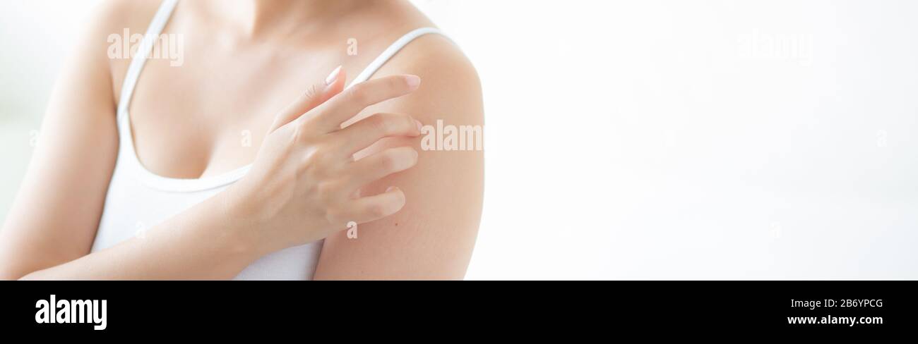 Bella giovane donna asiatica che applica crema e trattamento per la cura della pelle tocco sulla spalla, ragazza con lozione e idratante per la salute parte del corpo, la vita Foto Stock