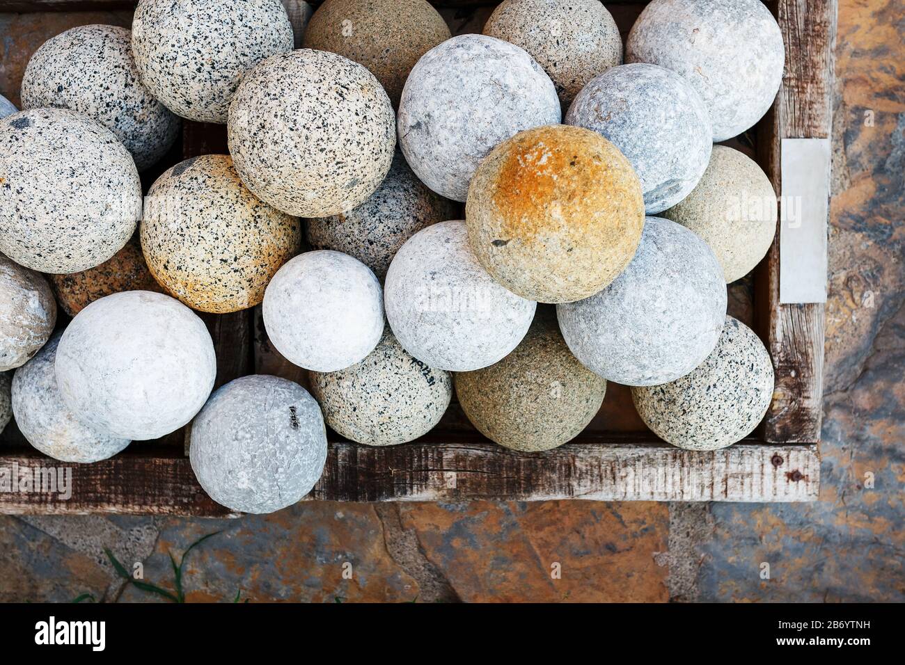 Palline di marmo di colore grigio in un cesto, vista dall'alto. Cartucce per armi antiche Foto Stock