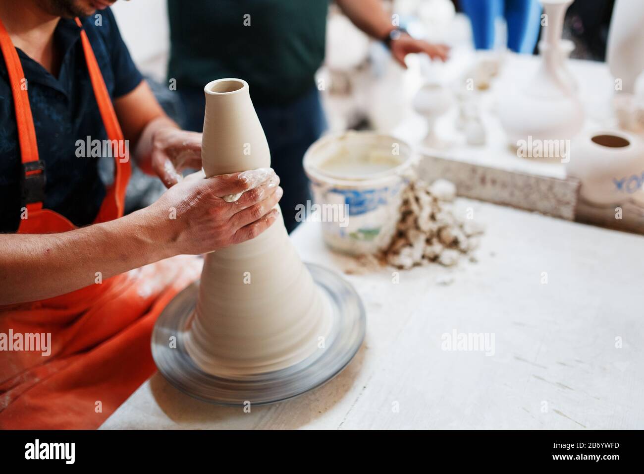 Mani di vasaio giovane, è stato prodotto su mani di gamma di un vasaio abilmente facendo una pentola di argilla bianca. Vaso di ceramicsof turco. Foto Stock