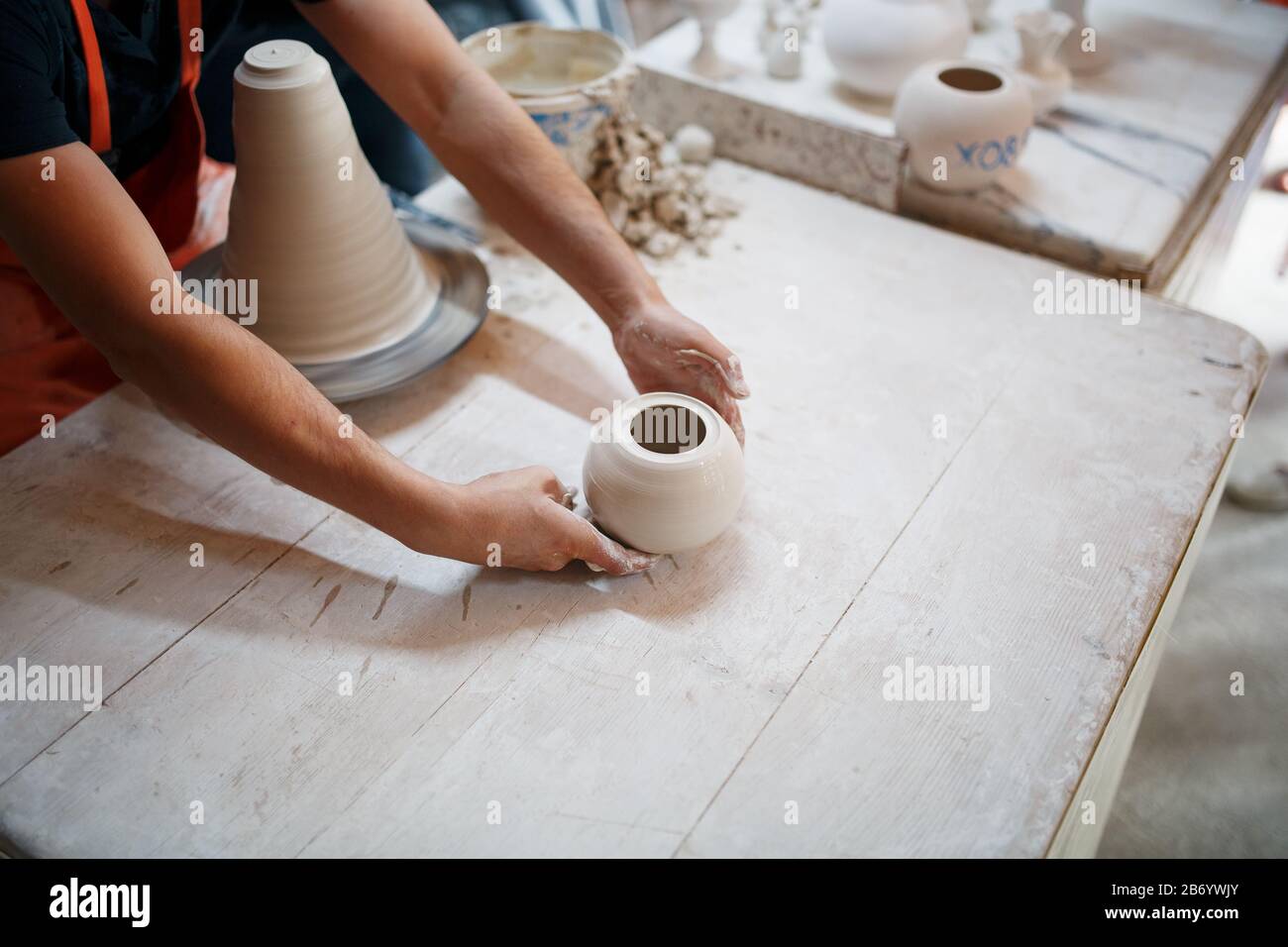 Mani di vasaio giovane, è stato prodotto su mani di gamma di un vasaio abilmente facendo una pentola di argilla bianca. Vaso di ceramicsof turco. Foto Stock