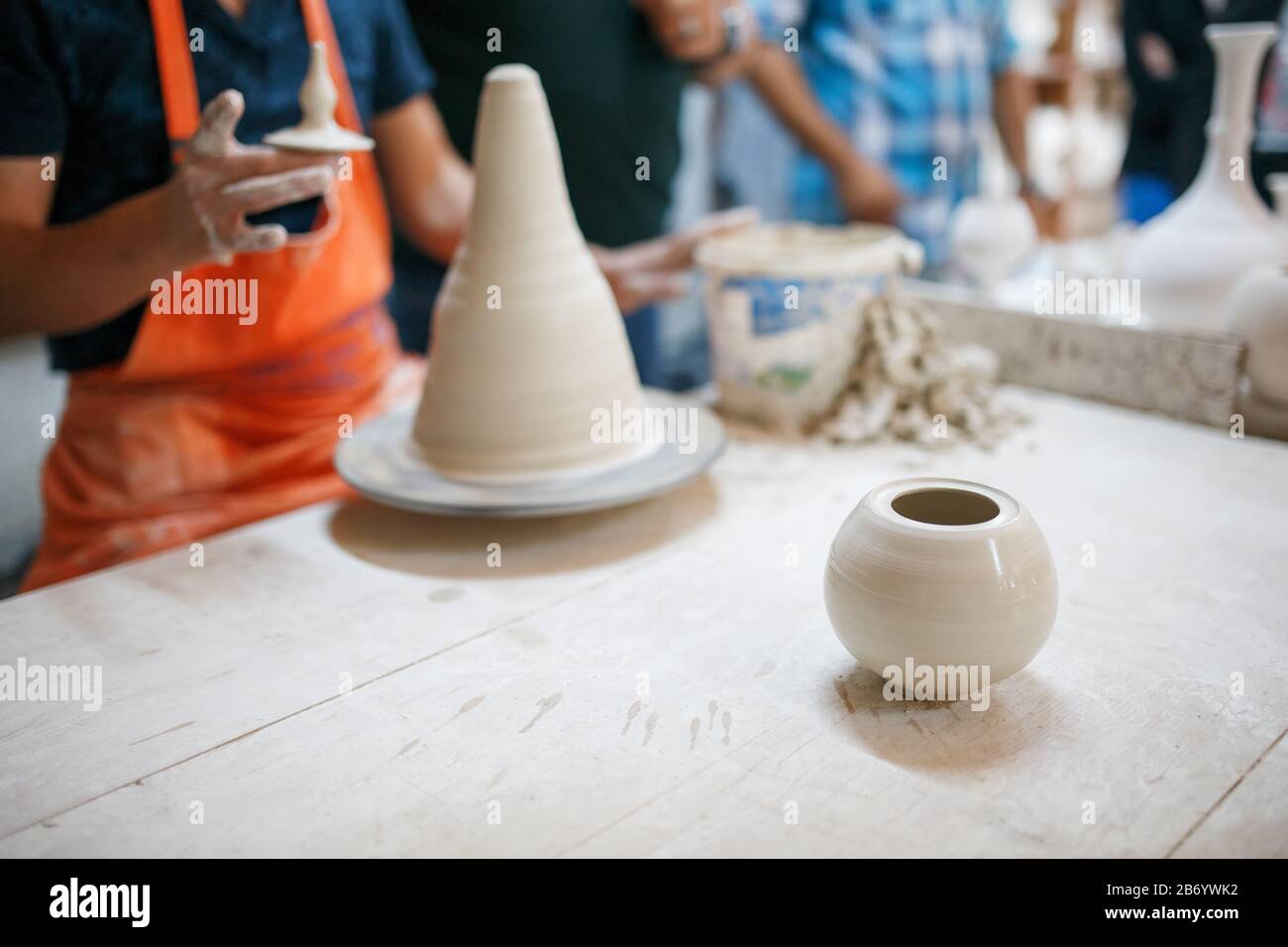 Mani di vasaio giovane, è stato prodotto su mani di gamma di un vasaio abilmente facendo una pentola di argilla bianca. Vaso di ceramicsof turco. Foto Stock