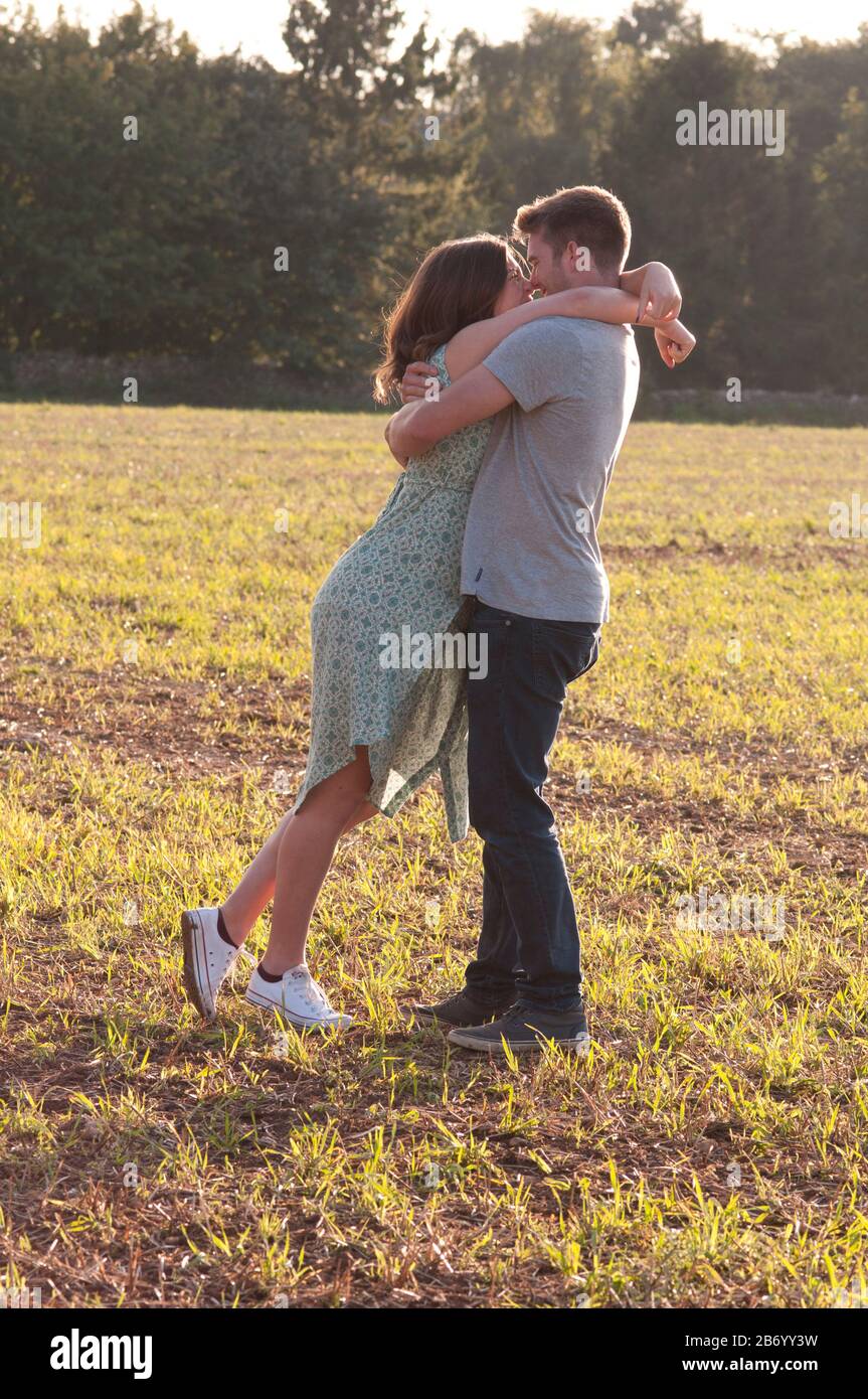 Giovane donna incinta con la sua partner, in piedi in un campo con le braccia l'una intorno all'altra Foto Stock