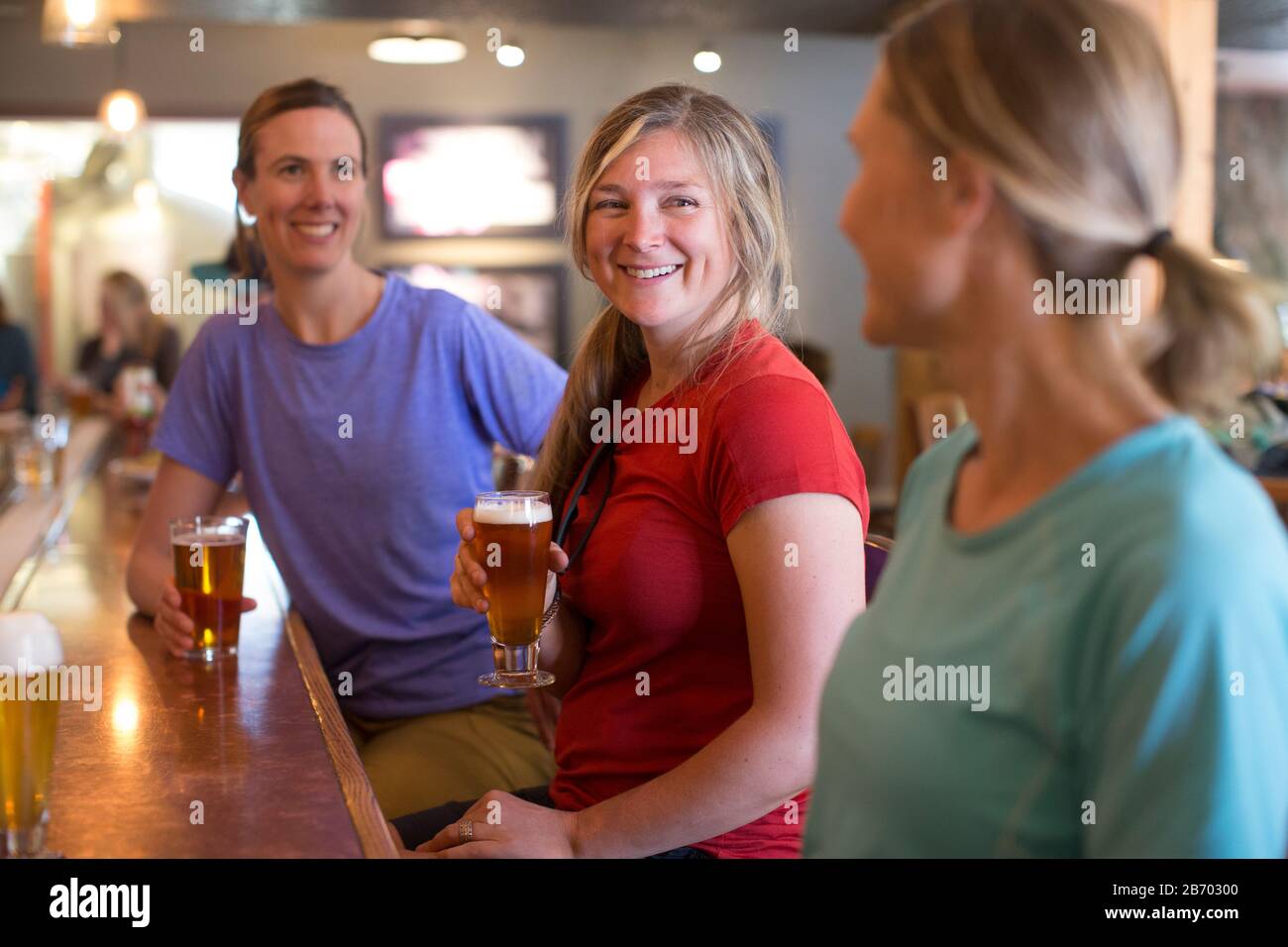 Tre amici femminili godono di una birra in una birreria nel campo governativo, O. Foto Stock