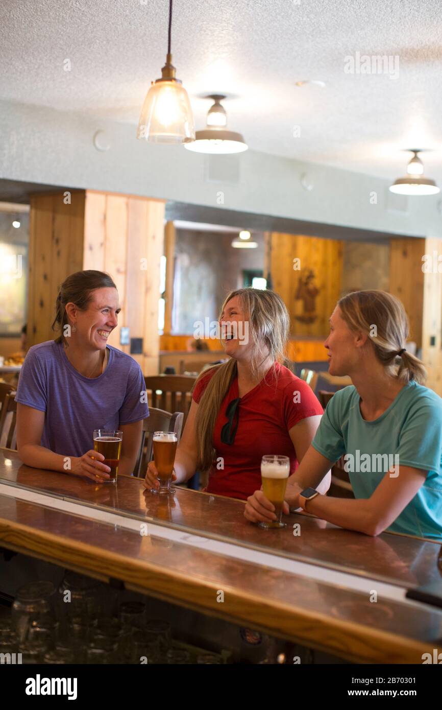 Tre amici femminili godono di una birra in una birreria nel campo governativo, O. Foto Stock