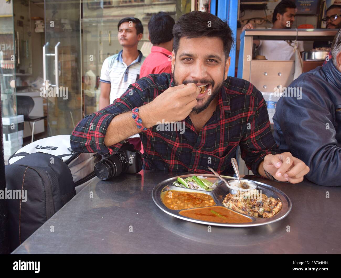 Choley Bhature - una persona indiana che mangia la bhature di chole a Delhi, Paharganj. Pane fritto con ceci. Cucina indiana di strada Foto Stock