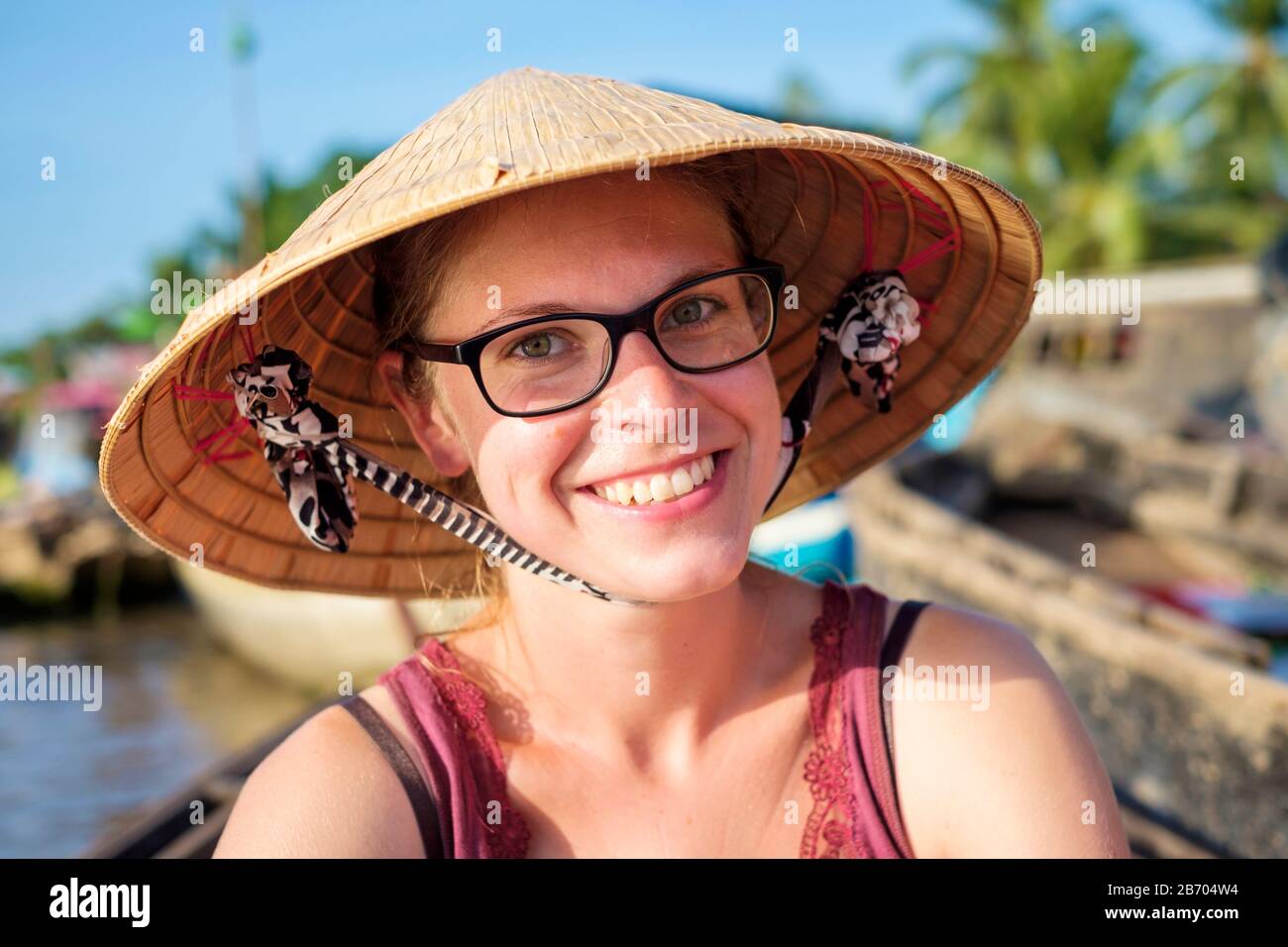 Giovane turista caucasico che indossa cappello conico vietnamita, mercato galleggiante Phong Dien, Can Tho, Delta del Mekong, Vietnam (MR) Foto Stock