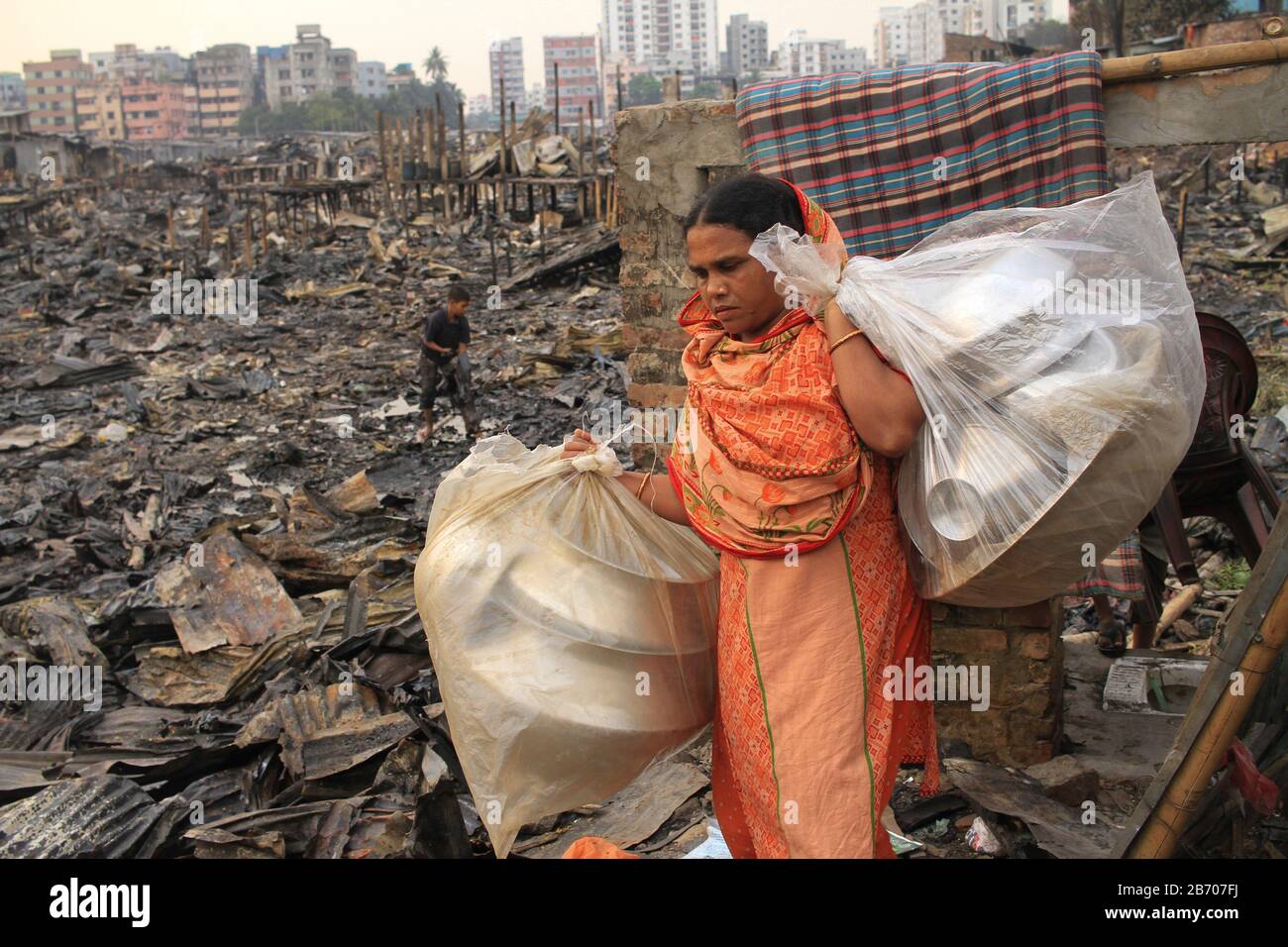 Dhaka, Bangladesh. 01st Gen 2000. Centinaia di barie sono state rasate al suolo, lasciando migliaia di senzatetto in un fuoco massiccio a Shialbari lato di Jhilpar slum, situato nella zona di Rupnagar di Mirpur 6 a Dhaka. La gente raccoglie i loro materiali appartenuti dalle ceneri dopo che un fuoco ha scoppiato al lato di Shialbari dell'area di slum di Jhilpar. (Foto Di Md Abu Sufian Jewel/Pacific Press) Credito: Pacific Press Agency/Alamy Live News Foto Stock