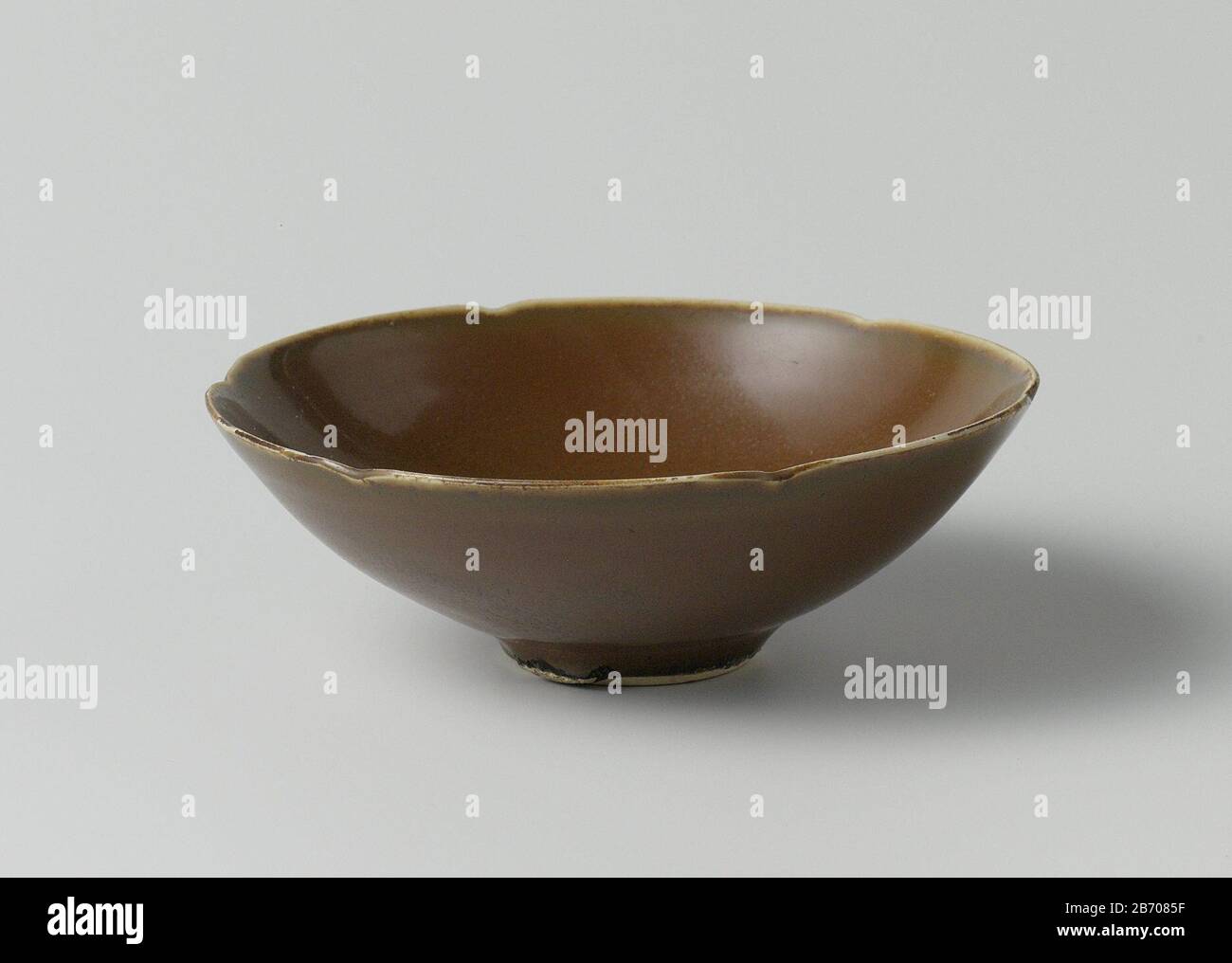 Kom met een bruin glazuur Kom van steengoed met zesmaal gelobde wand, bedekt met een bruin glazuur. Twee chip in de rand; bakzand aan de voetring. Ding. Produttore : pottenbakker: AnoniemPlaats fabbricante: China Dating: CA. 960 - ca. 1279School / stijl: Song-dynastie (960-1279) Physical kenmerken: Steengoed met een bruin glazuur Material: Steengoed glazuur Techniek: Draaiend bewerken / vormen / bakken / glazuren dimensioni: H 3,9 cmrand: D 11,3 cmvoet: D 3,4 cm Foto Stock
