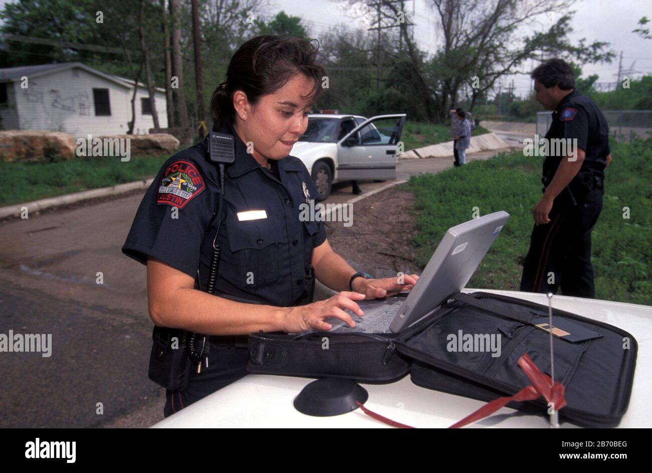 Austin, Texas USA: Poliziotto femminile ispanico che utilizza il computer portatile per completare i rapporti sul campo. SIGNOR ©Bob Daemmrich Foto Stock