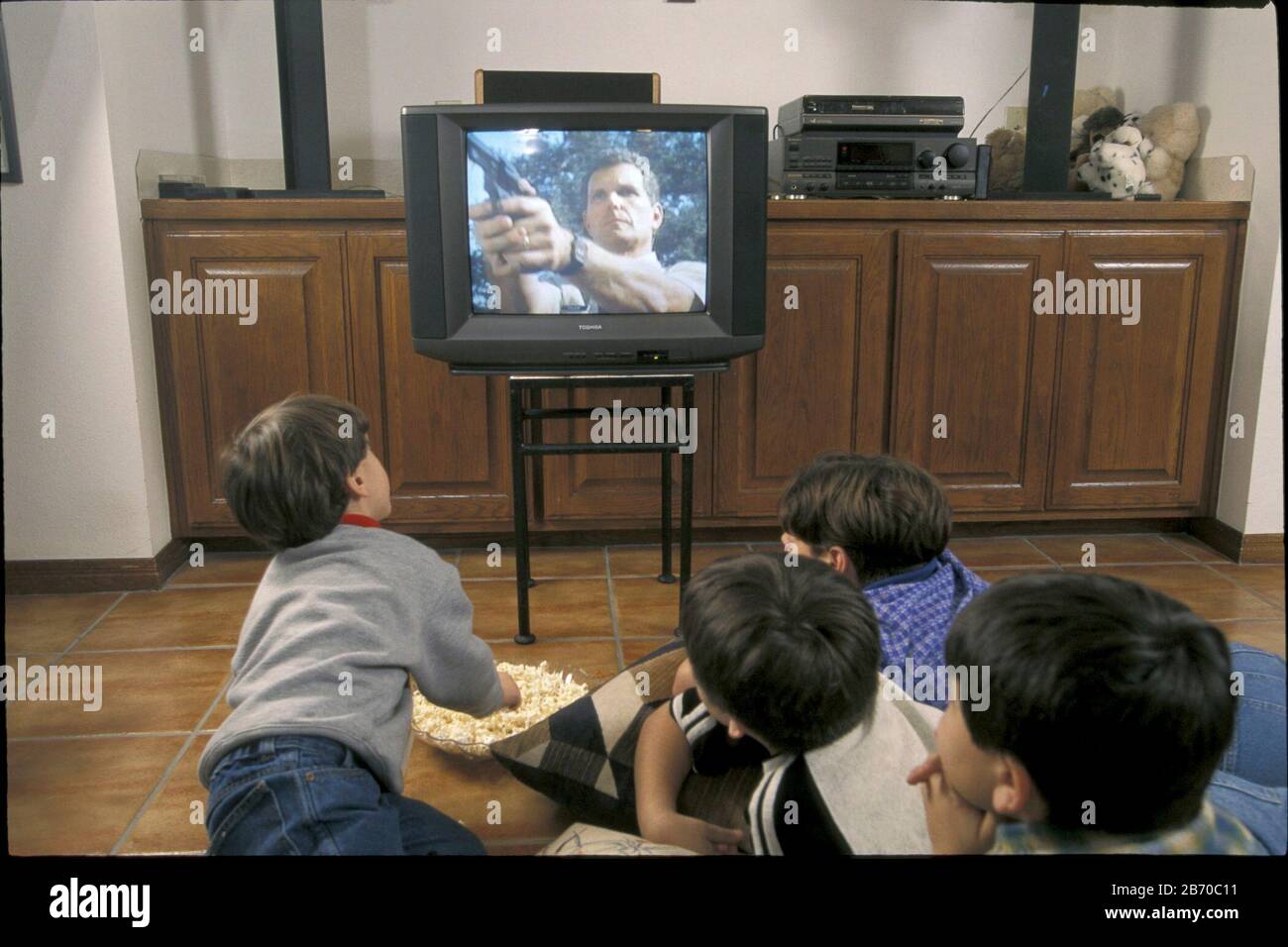 Violenza televisiva; i giovani guardano un film violento in televisione. SIGNOR ©Bob Daemmrich Foto Stock