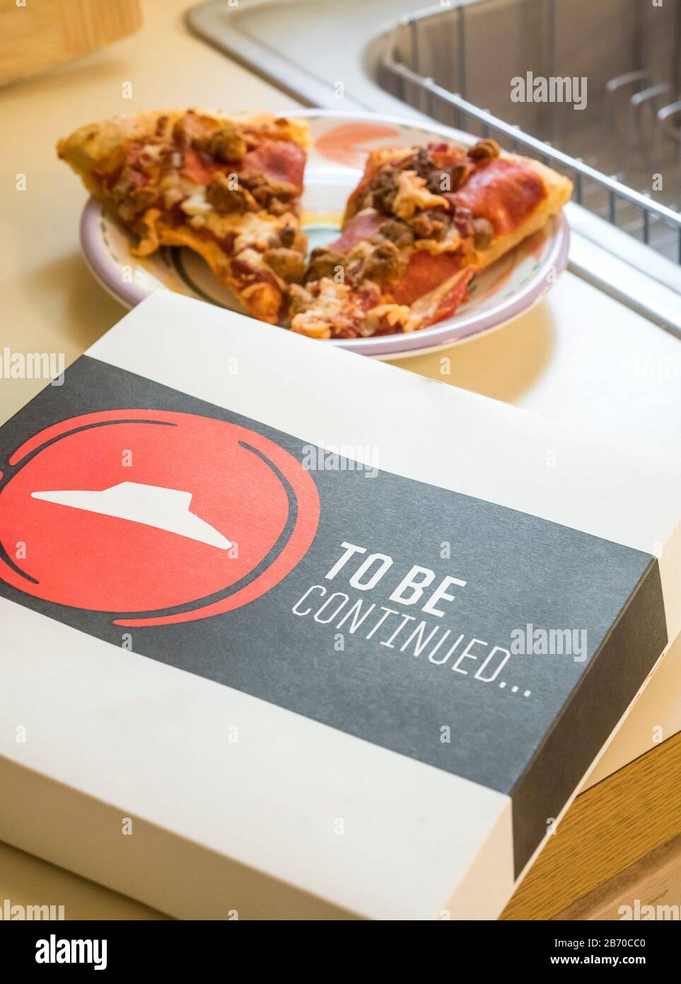 Pizza Hut Da Continuare Box con 2 fette di pizza rimaste sullo sfondo. Foto Stock