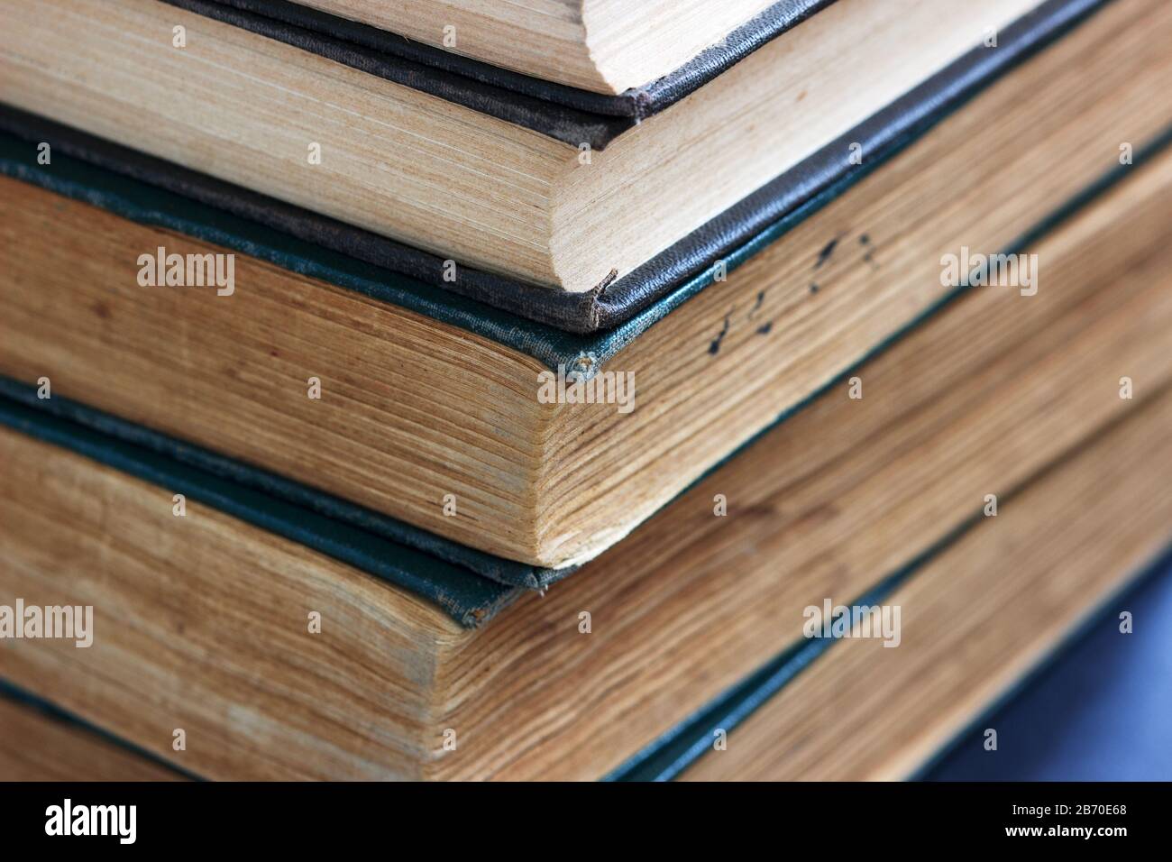 Vecchi libri con copertine sfilacciate su un tavolo scuro. Foto Stock