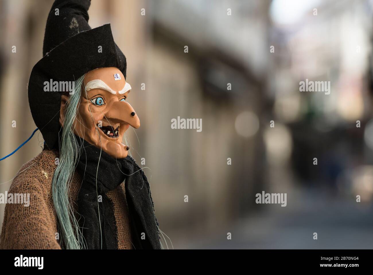 Street scene nella zona della città vecchia di Baiona, con primo piano di una bambola strega in vendita. (Prezzo sulla fronte) Spagna Foto Stock