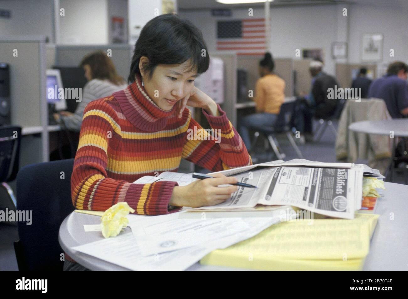 Austin Texas USA, 2002: Donna asiatica-americana cerca annunci classificati al centro di occupazione di stato. SIGNOR ©Bob Daemmrich Foto Stock