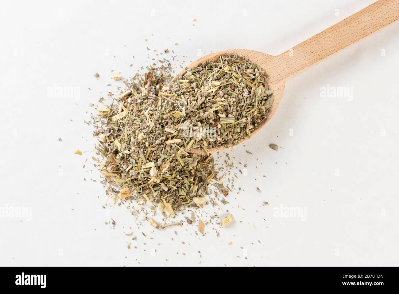 Erba di legno di mosto o in erba di Absinthii latina o in cucchiaio di legno isolato su sfondo bianco. Erbe medicinali curative. Medicina erboristica. Alternativa Foto Stock