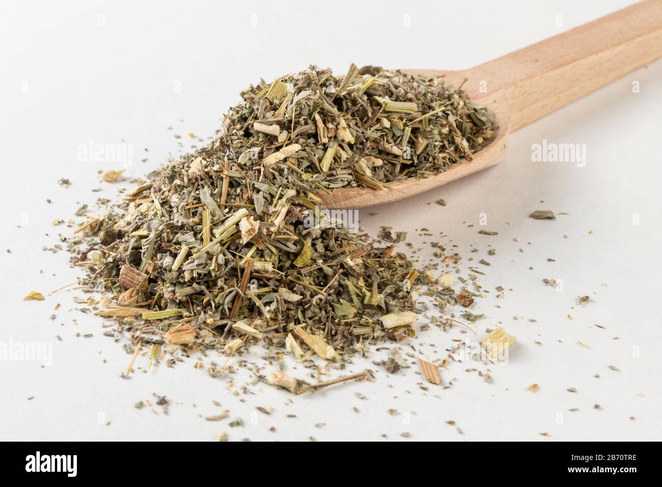 Erba di legno di Erba o in latino erba di Absinthii in cucchiaio di legno isolato su sfondo bianco. Erbe medicinali curative. Medicina erboristica. Farmaco alternativo Foto Stock